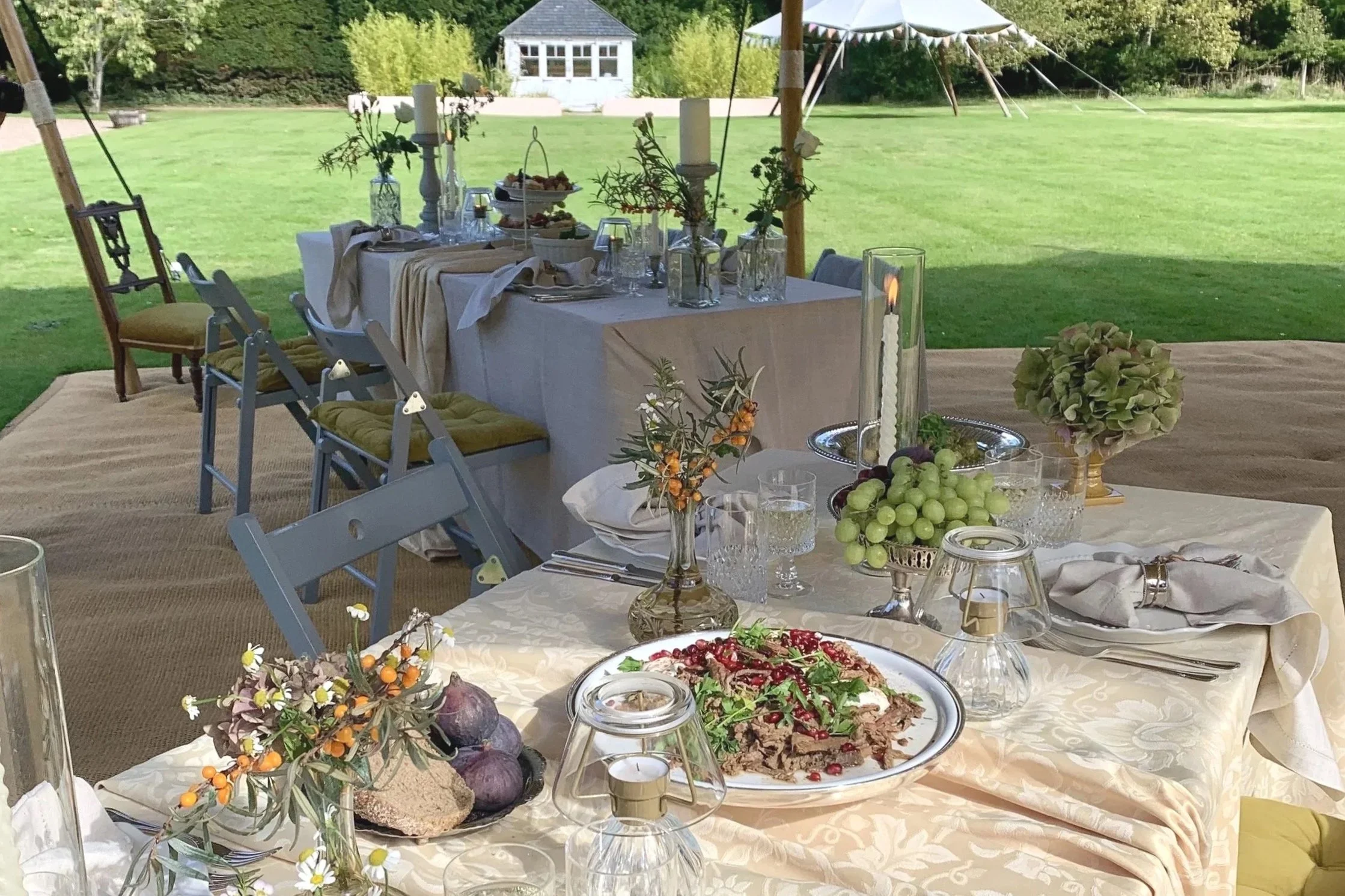 Outdoor dining tablescape with floral centrepieces, fresh fruit and sharing platters, created by Laura Somborn with catering by Coast to Country Catering at Netherbryres House.