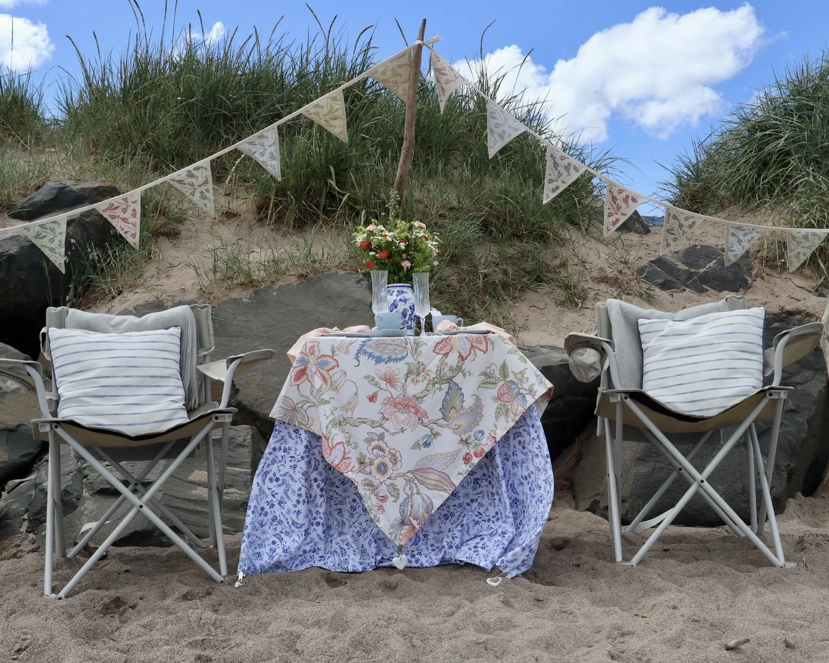 Bespoke anniversary celebration styled by Laura Somborn on Spittal Beach, Northumberland, featuring elegant table styling, seasonal flowers and heritage tableware for an unforgettable seaside celebration.