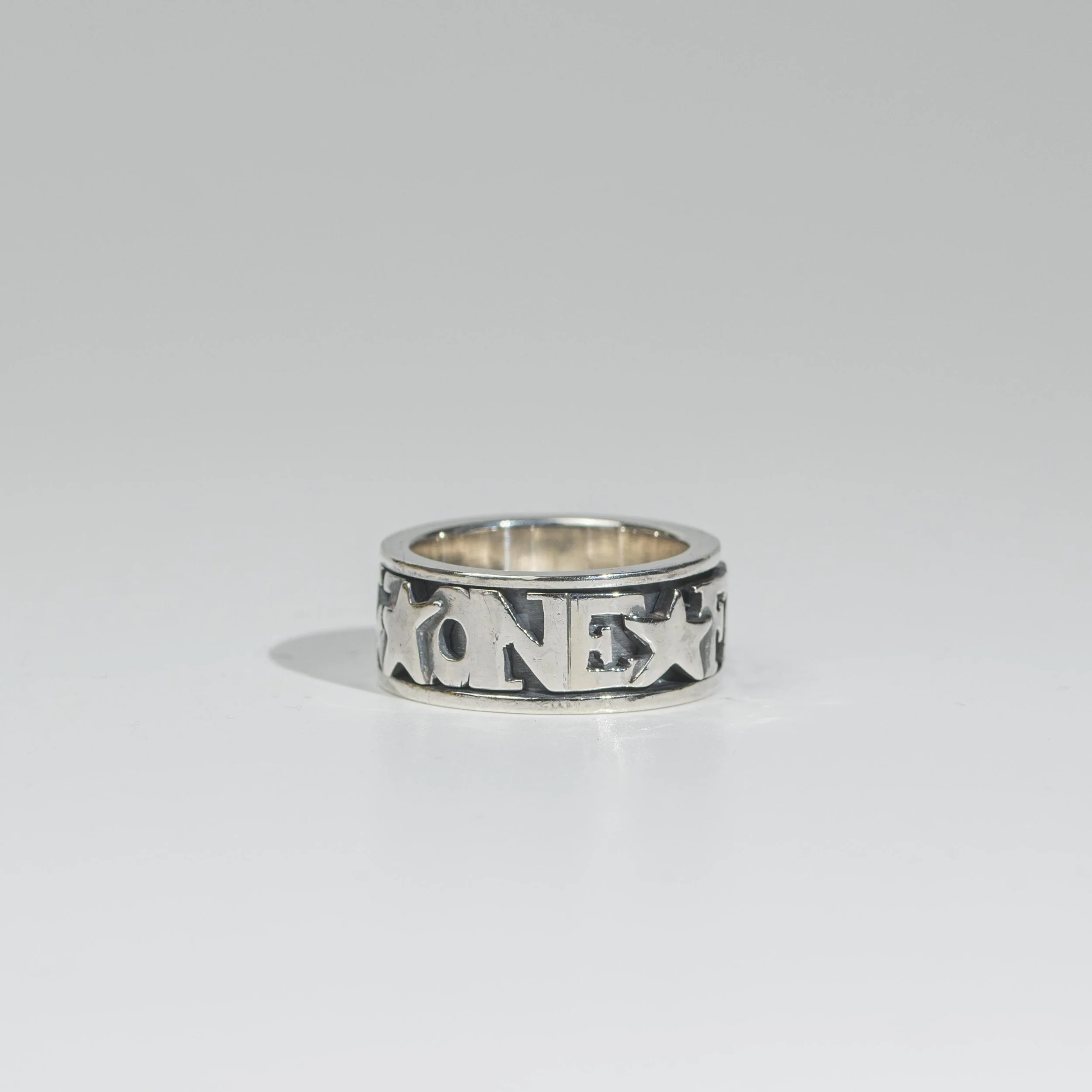 Sterling Silver Spin-ring with cut-out letters reading "One For Sorrow" and stars.