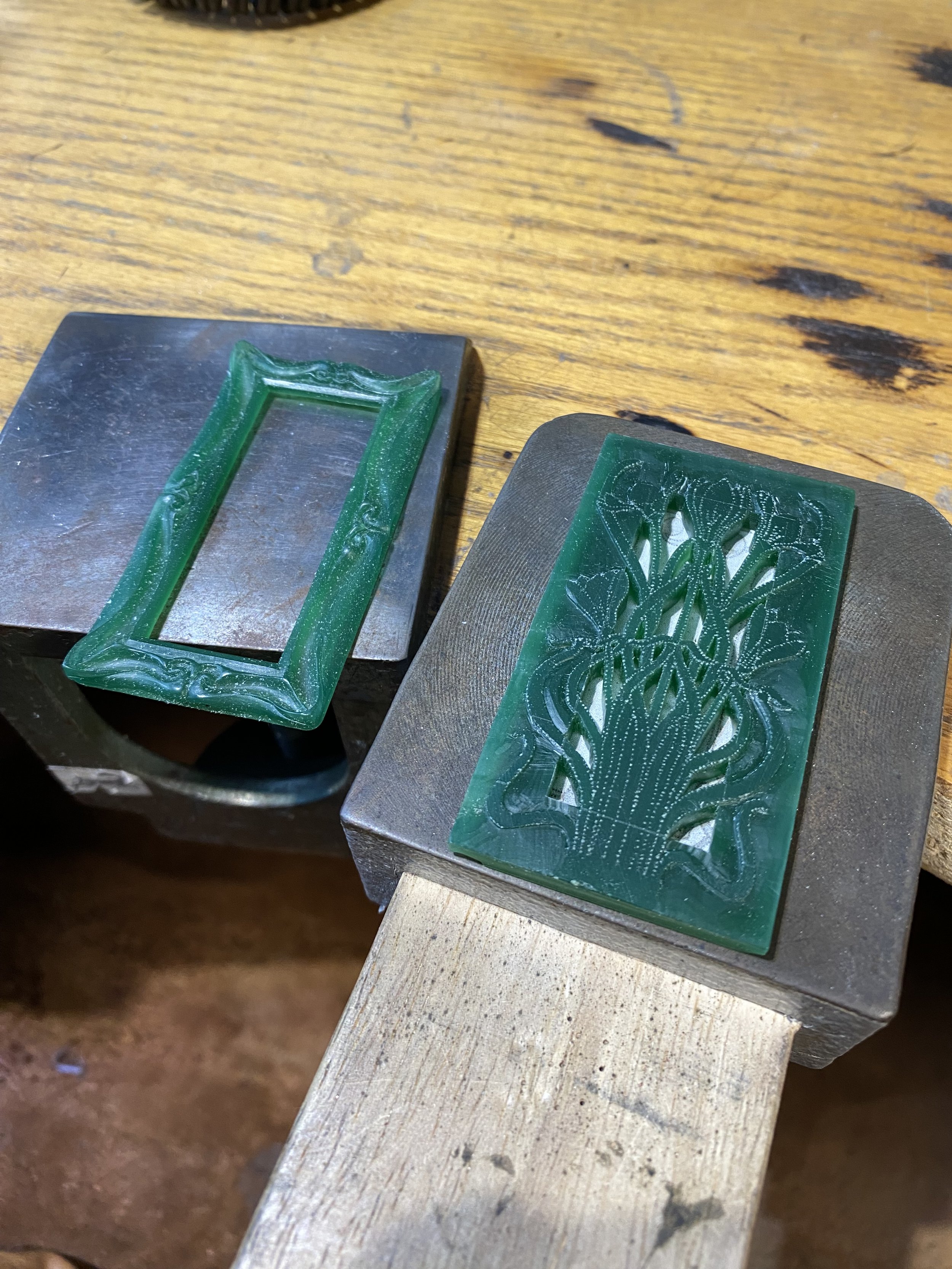 Both of the carvings side-by-side. I placed a piece of paper behind the flower frame carving to show the centre cut-outs. 