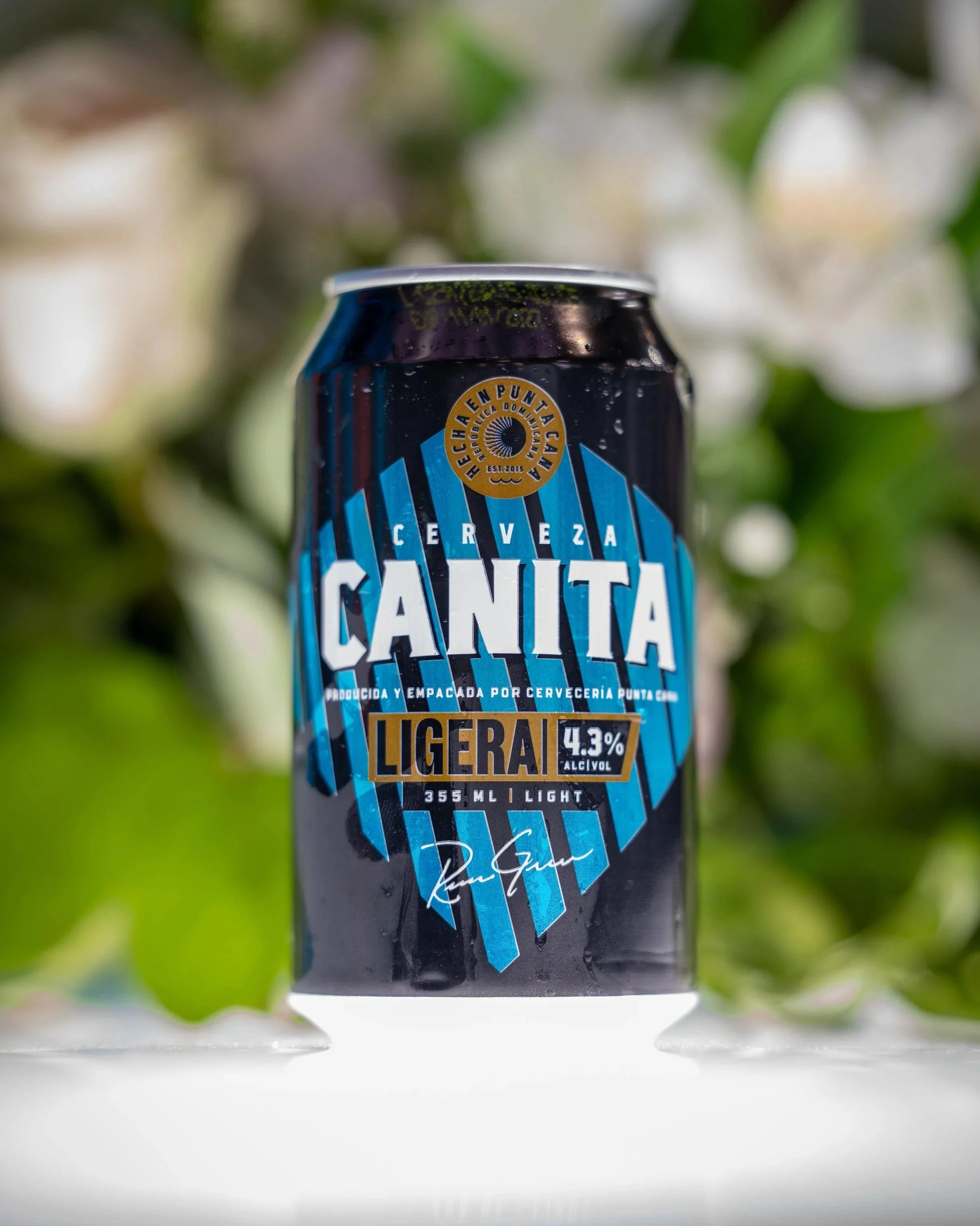 Canette de bière légère Canita, 355 ml, 4,3% d'alcool, avec un fond flou de feuilles vertes.