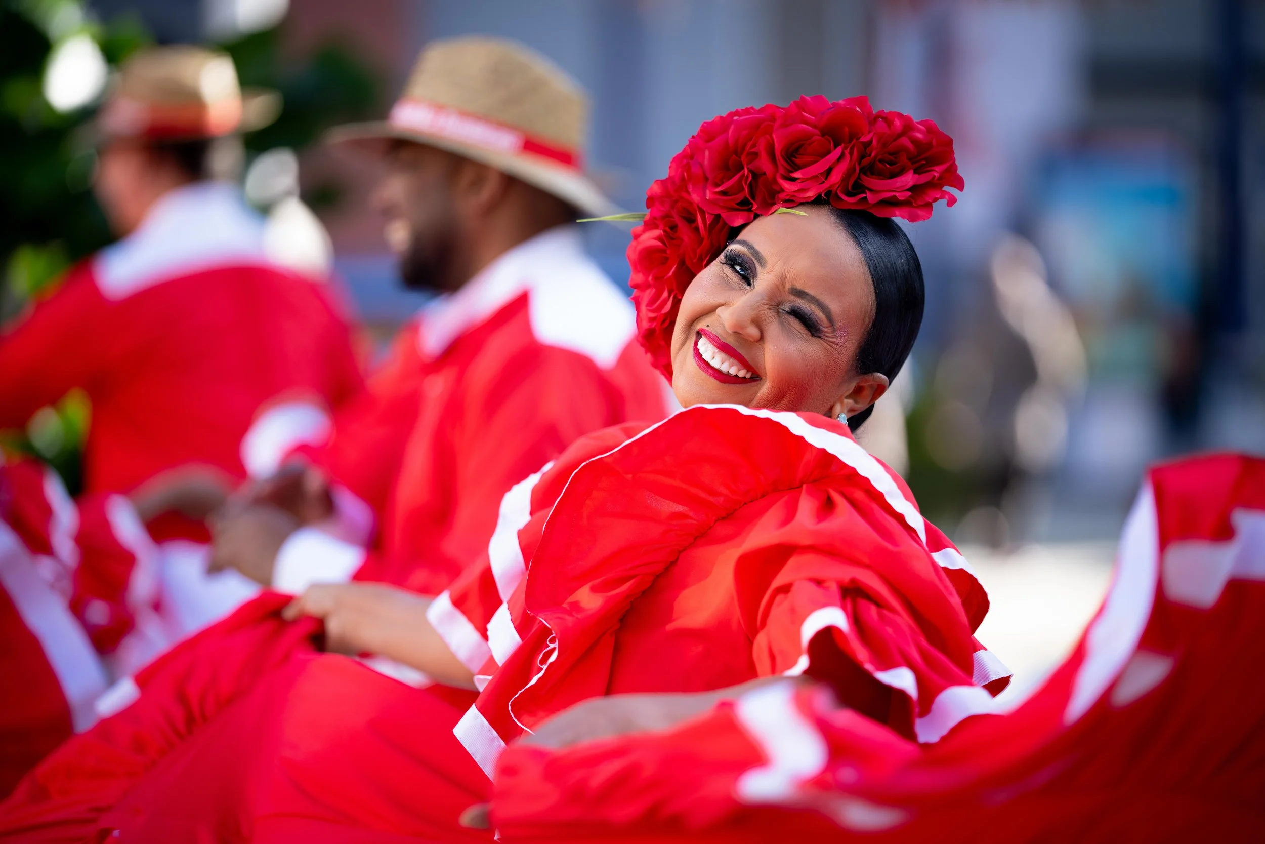 Fête traditionnelle colombienne avec femmes en costumes rouges et femmes portant des fleurs rouges sur la tête
