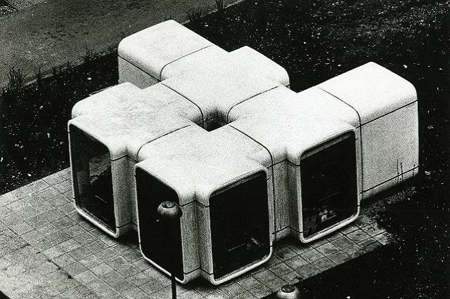 A set of modern, modular, and cube-shaped outdoor seating units arranged in a square pattern on a paved surface.