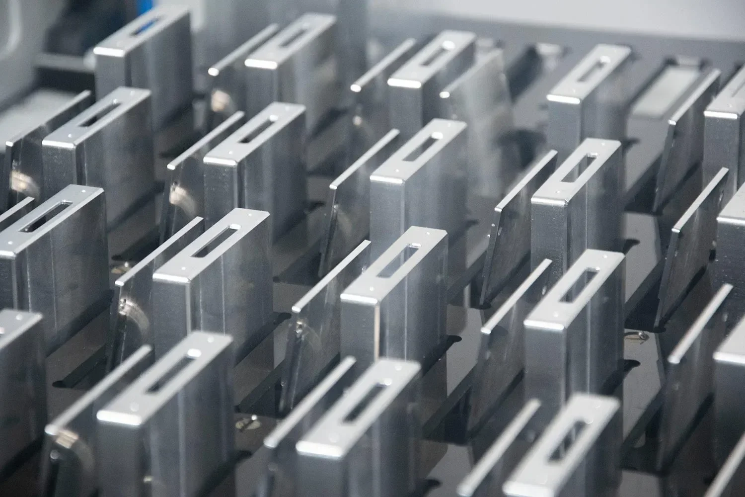 A close-up view of multiple metallic components arranged in rows, likely part of a mechanical or industrial assembly.