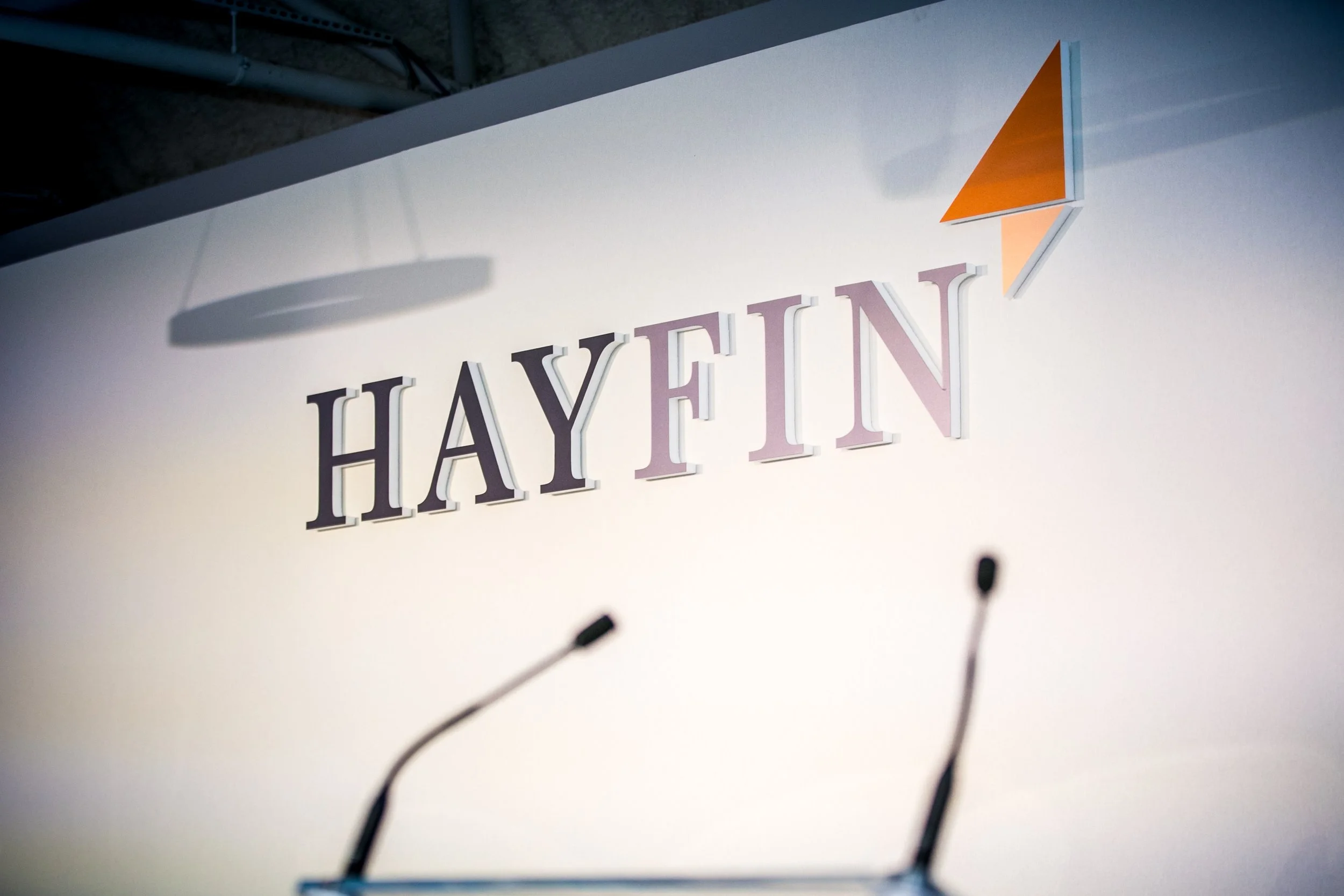 Close-up view of a sign with the word 'HAY' in large letters and 'HUT' in smaller letters, featuring an orange and white geometric design on the upper right corner.