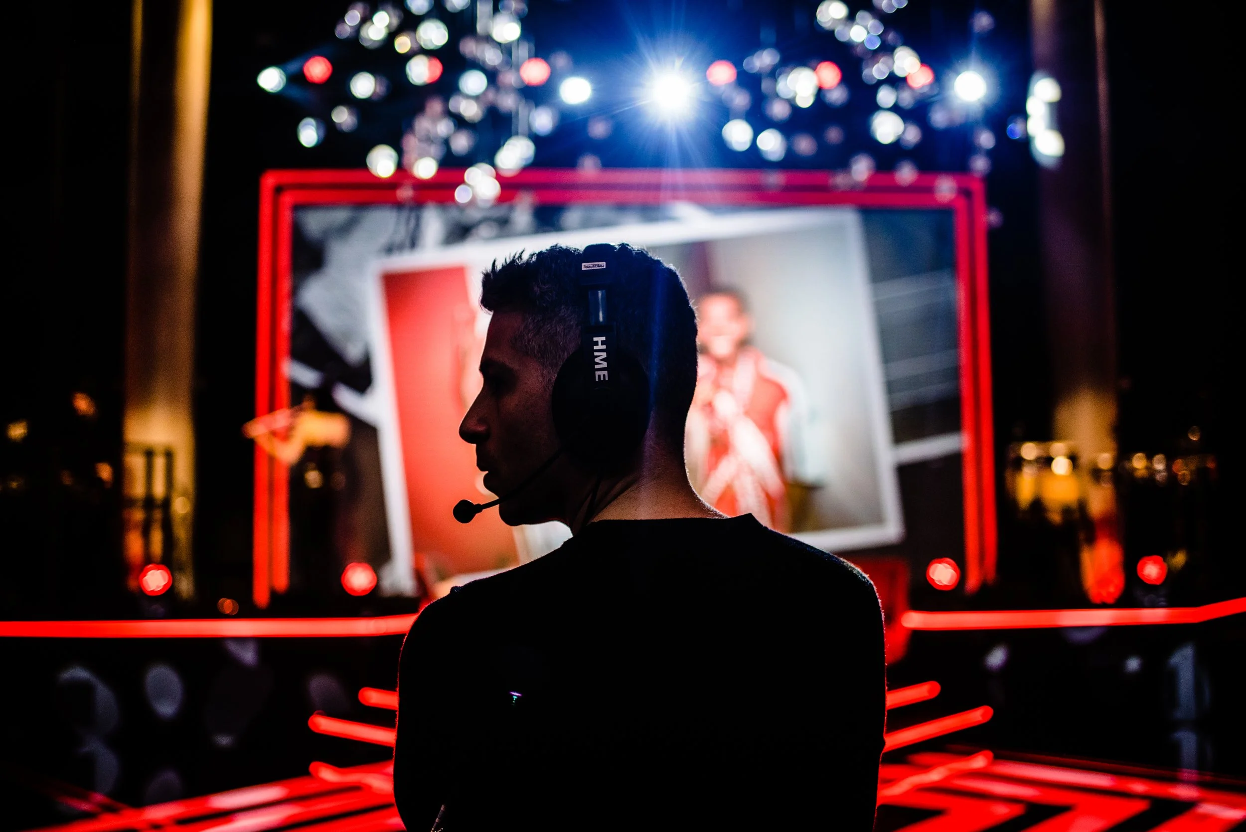 Stas Anastasiou wearing headphones with colourful, illuminated display featuring a large screen with various bright lights and neon accents in the background for a Bar Mitzvah celebration