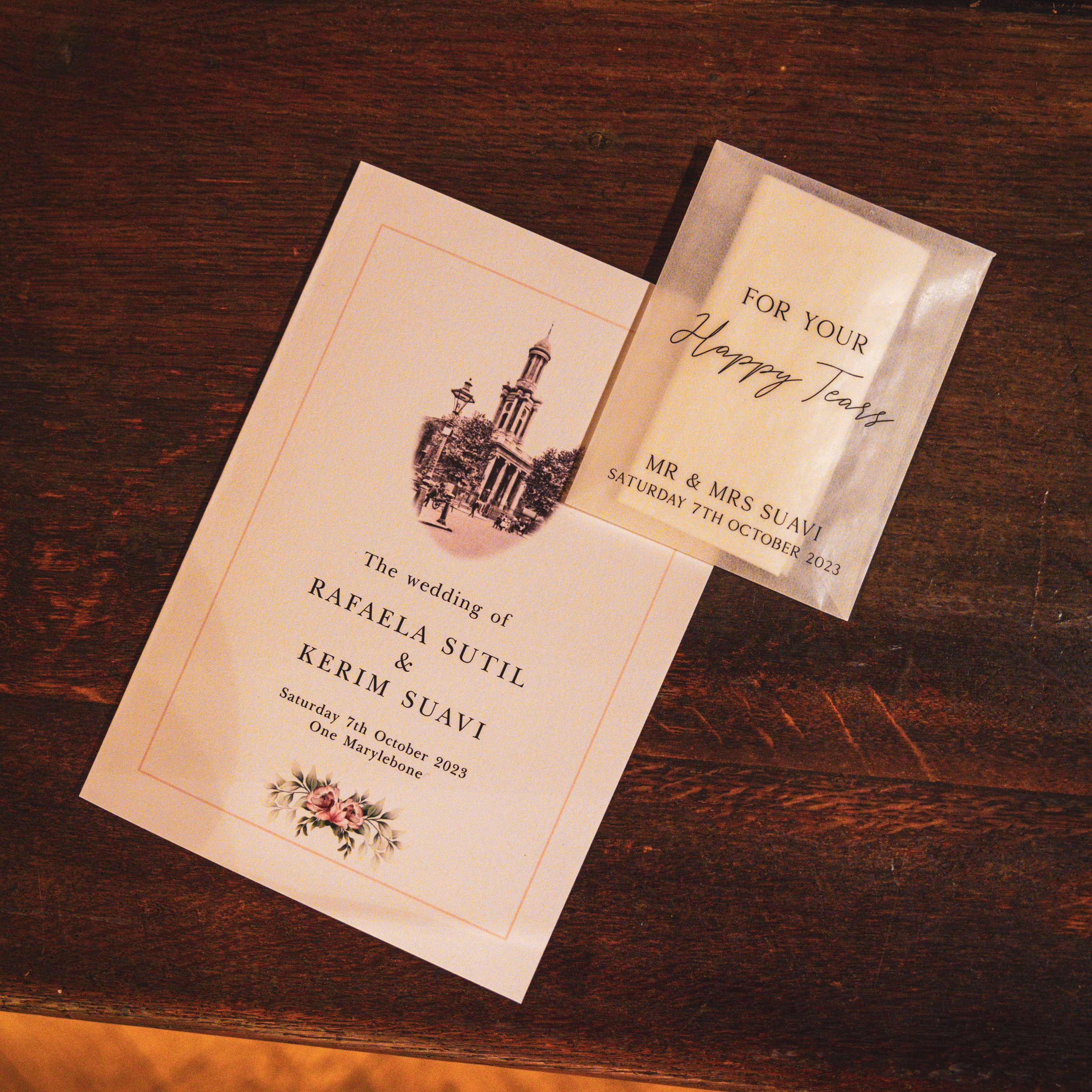 Wedding invitation card with floral design on a wooden surface.