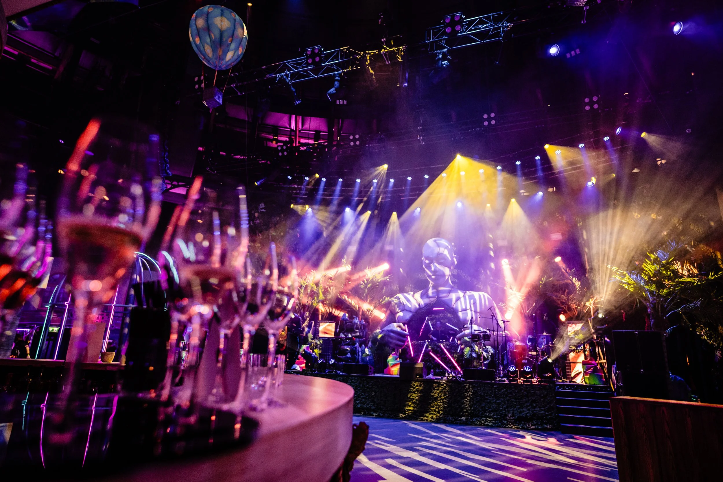A vibrant indoor party Bar Mitzvah scene with colorful lighting, drinks on tables, and balloons for Camden rock style 