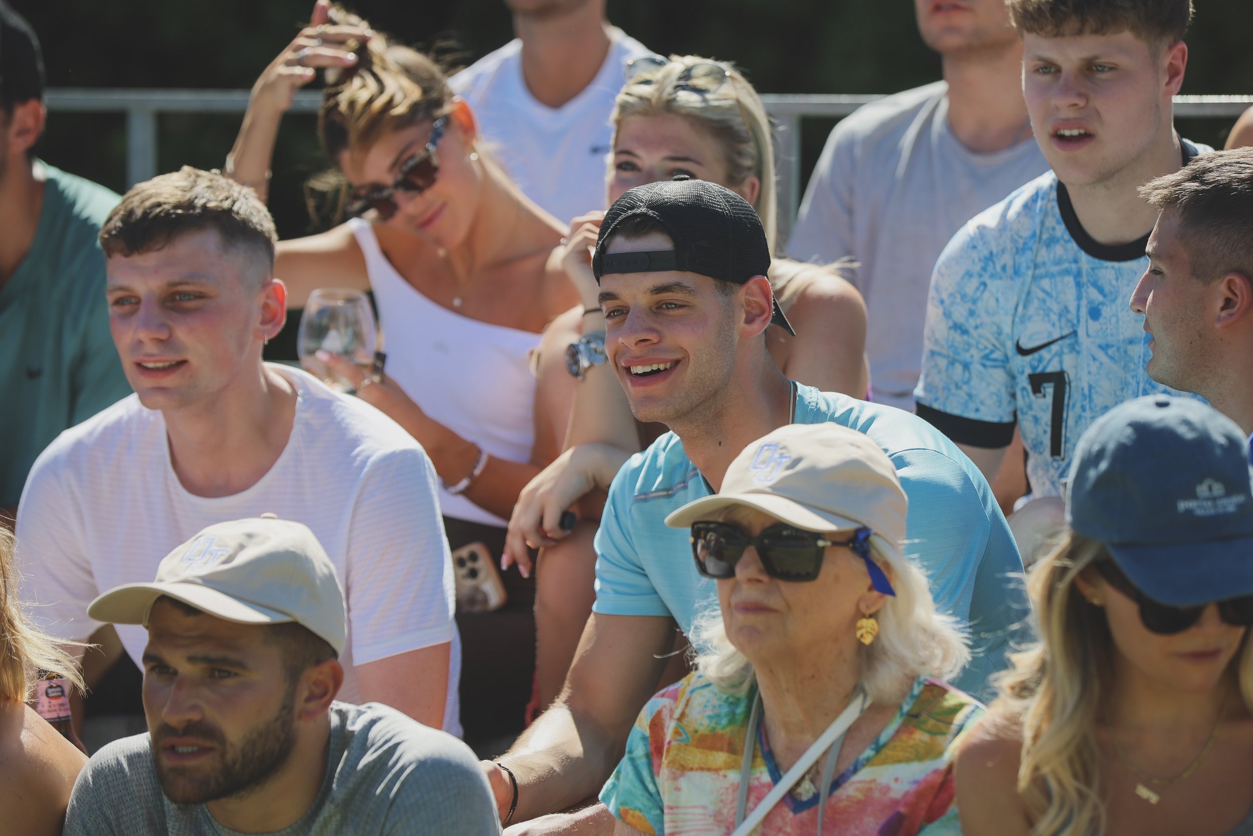 Group of people outdoors, sitting and standing, some wearing hats and sunglasses, engaged in conversation during a sunny day at Anantara Villa Padierna Resort in Marbella