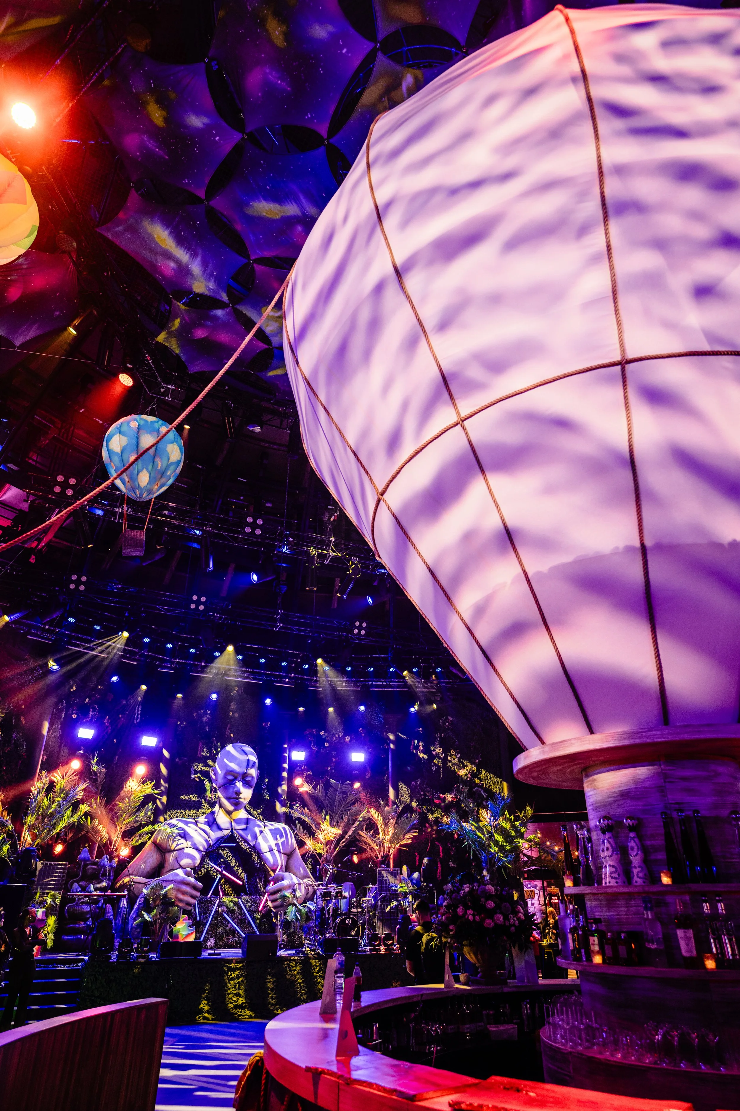 Interior of a vibrant Bar Mitzvah  with colorful lighting, hanging lanterns, and a decorative statue.