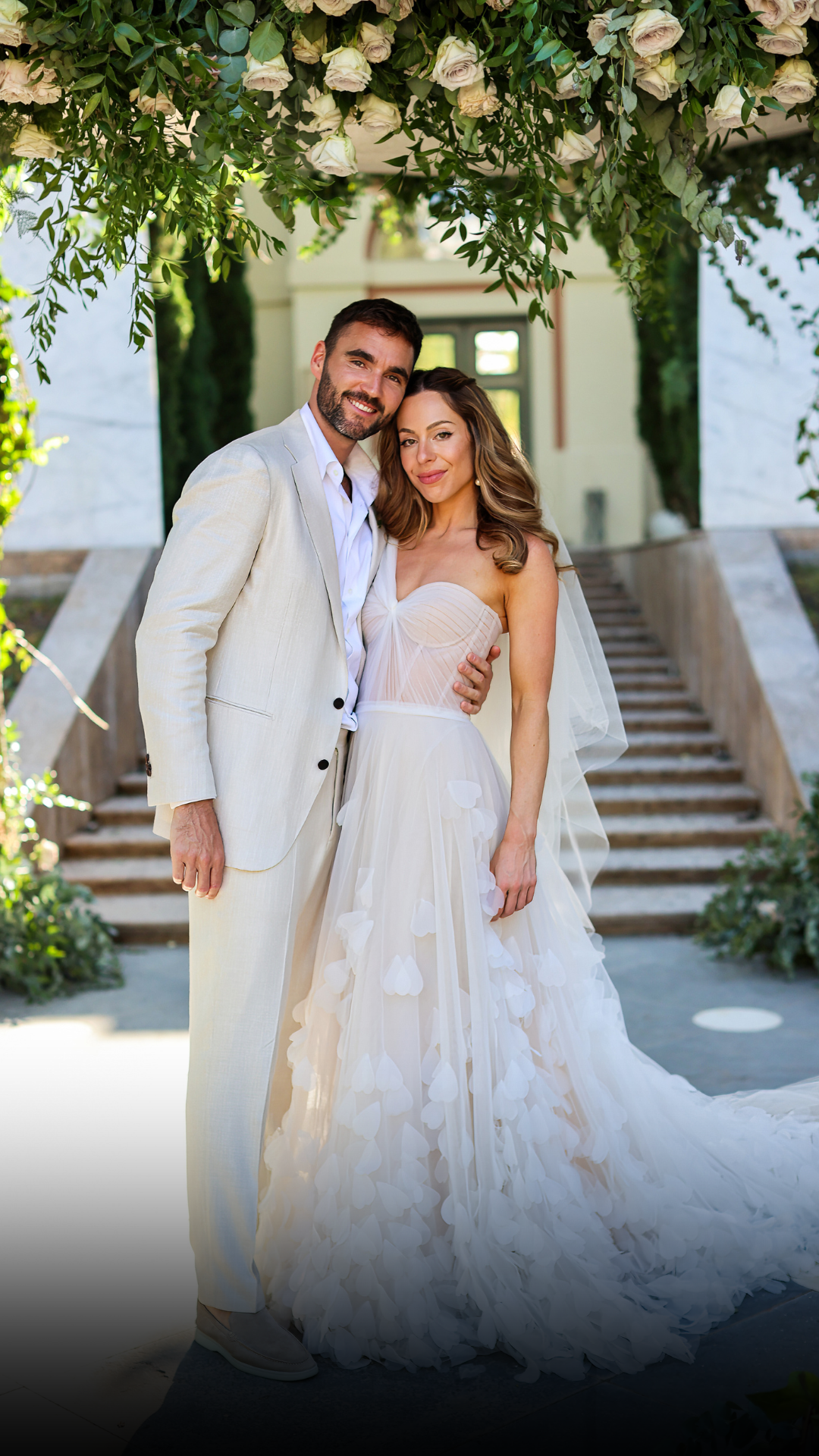 A happy couple married in Marbella at Anantara Villa Padierna Resourt. White florals and beige suit with wedding dress