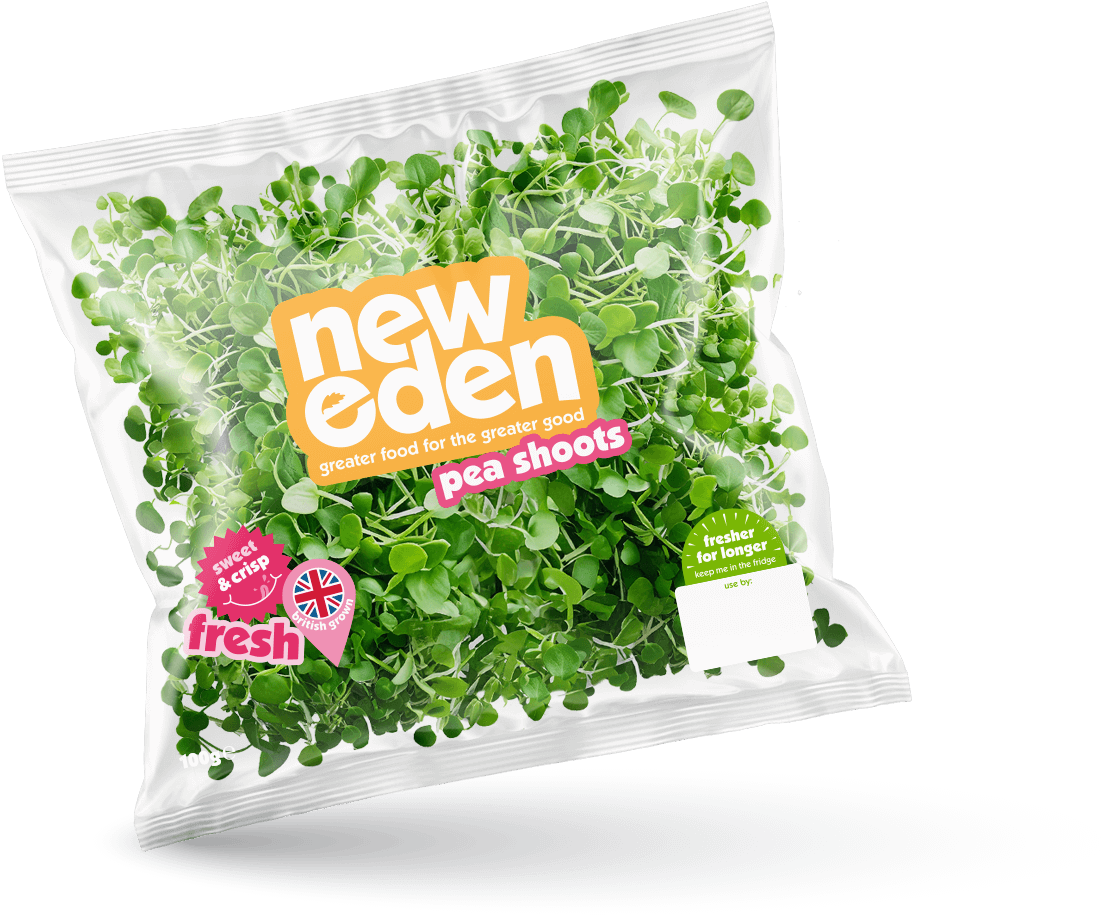 A package of New Eden pea shoots with fresh green microgreens inside. The packaging is transparent with colorful labels, including a pink label that says "fresh" and a green label indicating it is for longer freshness.