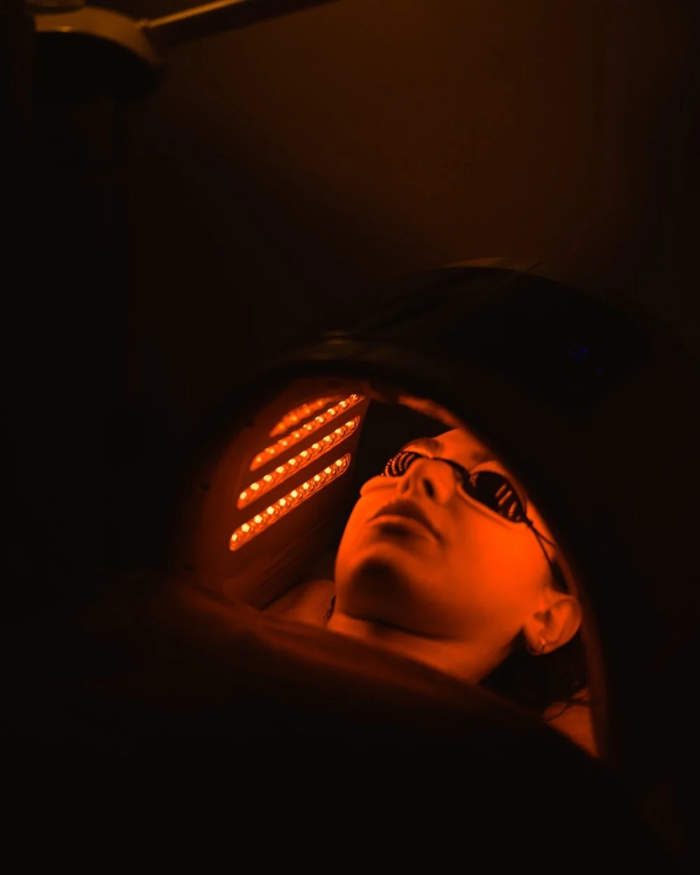 A woman receiving red light therapy for skin