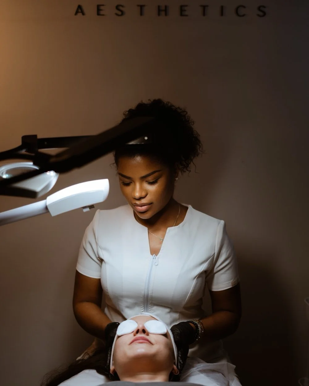 Aesthetician Camila Firetto performing a facial treatment on a woman in a her West London clinic.