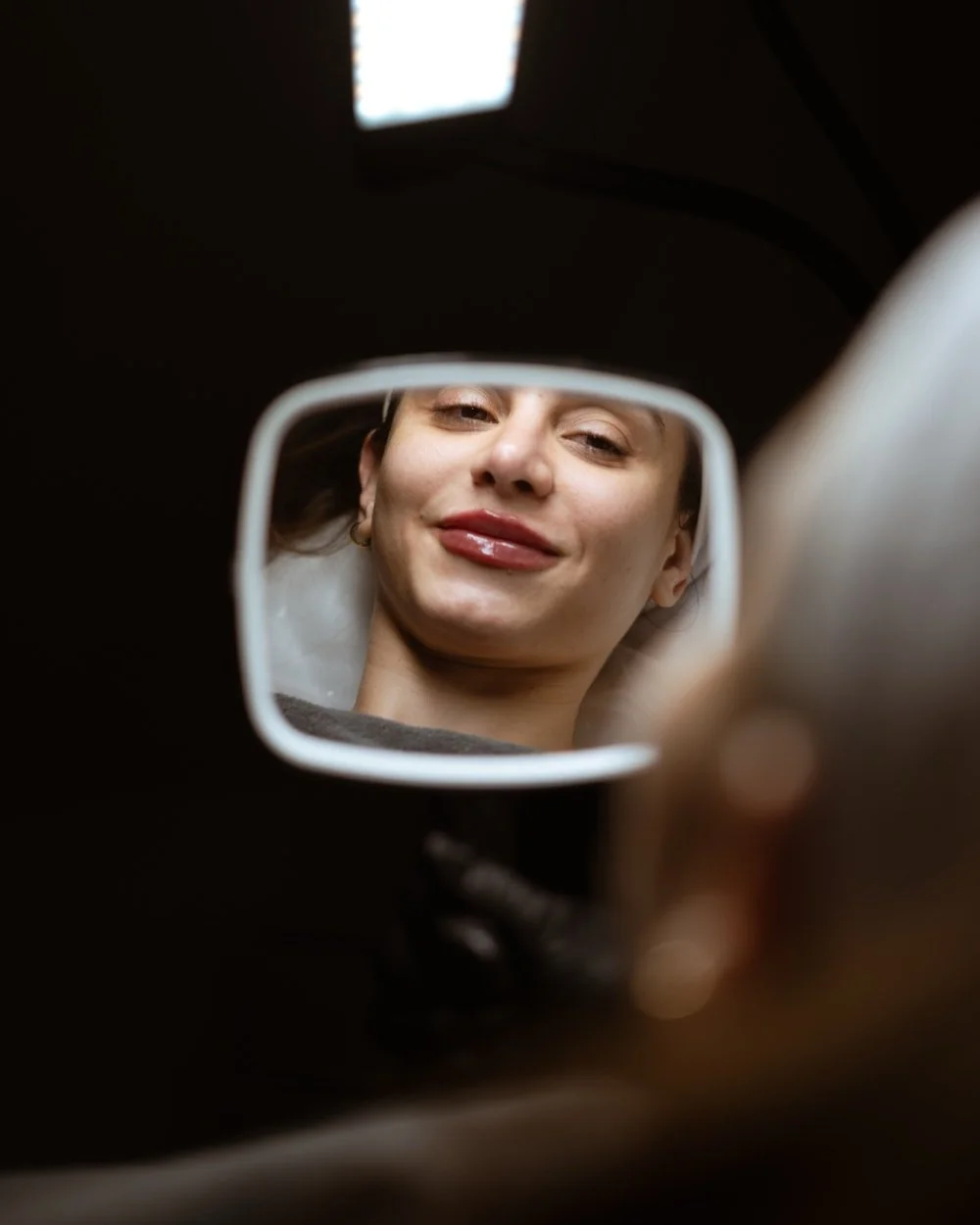 A woman admiring her lip filler results
