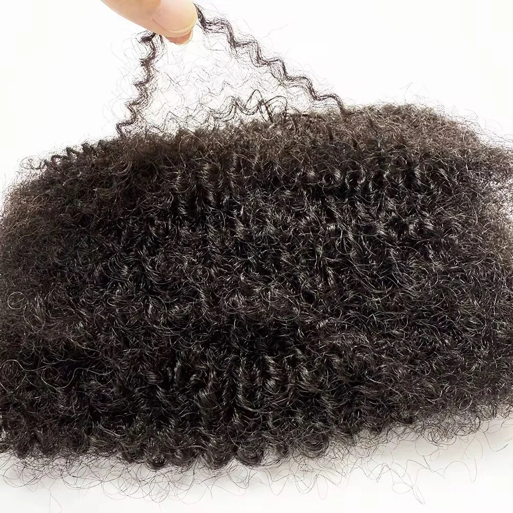 Close-up of curly, black hair extensions or natural hair on a white surface, with a hand holding a section of the hair.