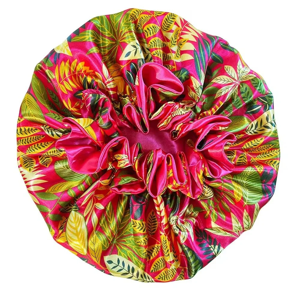 A vibrant, colorful, floral-patterned fabric scrunchie with shades of pink, yellow, green, and black, arranged in a circular shape.