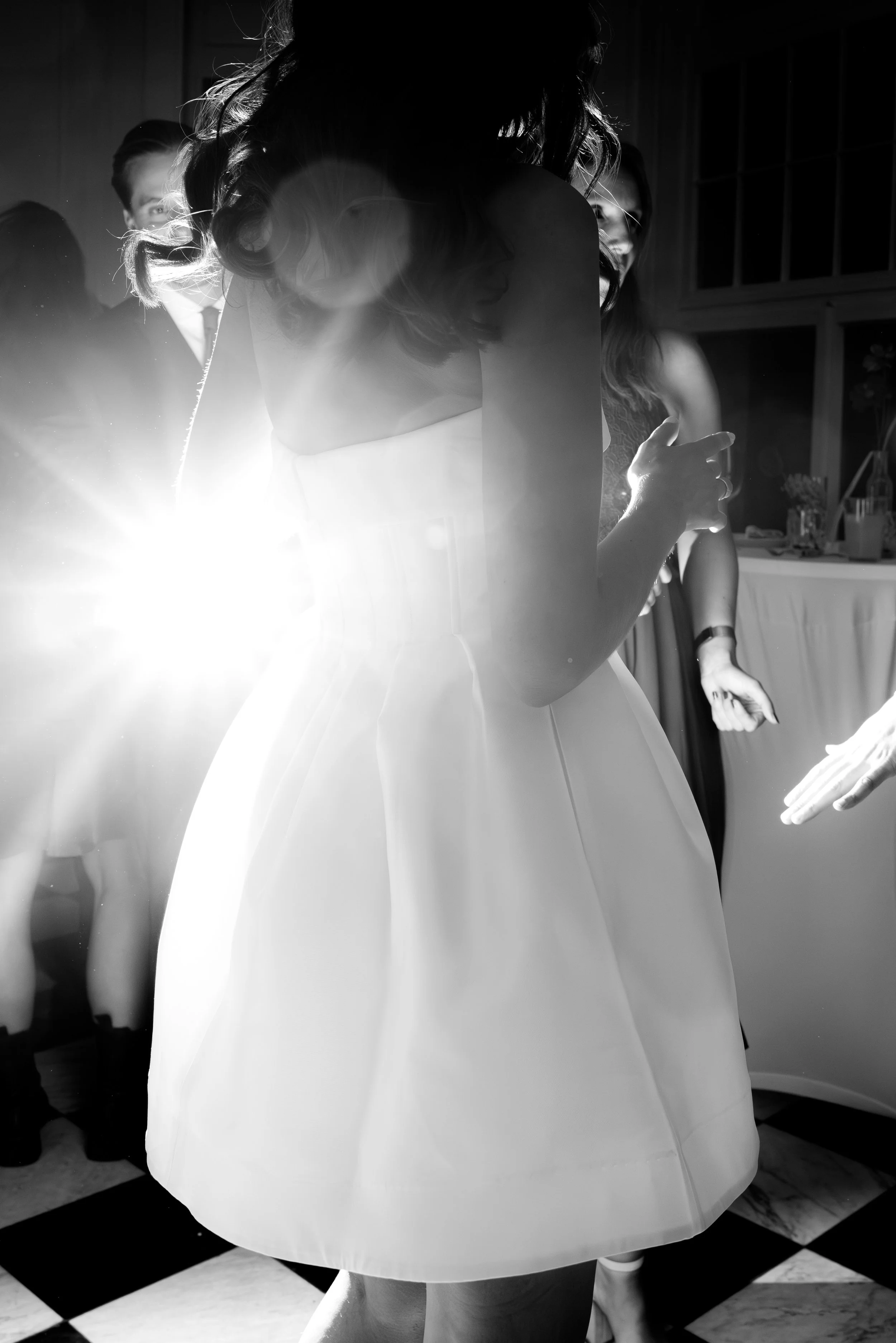 People dancing at a party with bright backlighting
