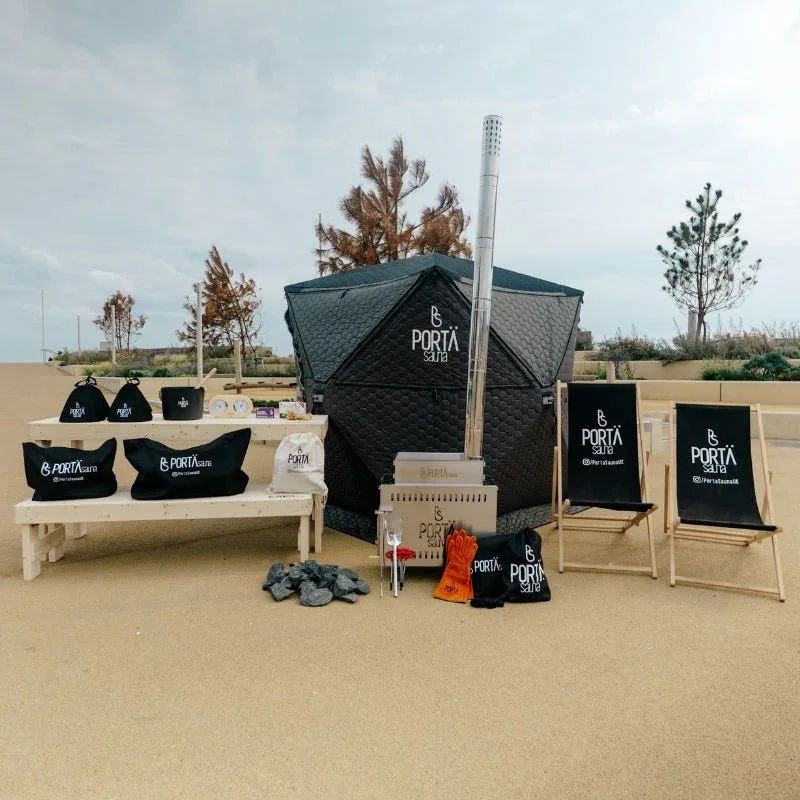 Beachside pavilion with promotional items for Porta Sauna, including bags, chairs, and a small outdoor sauna.