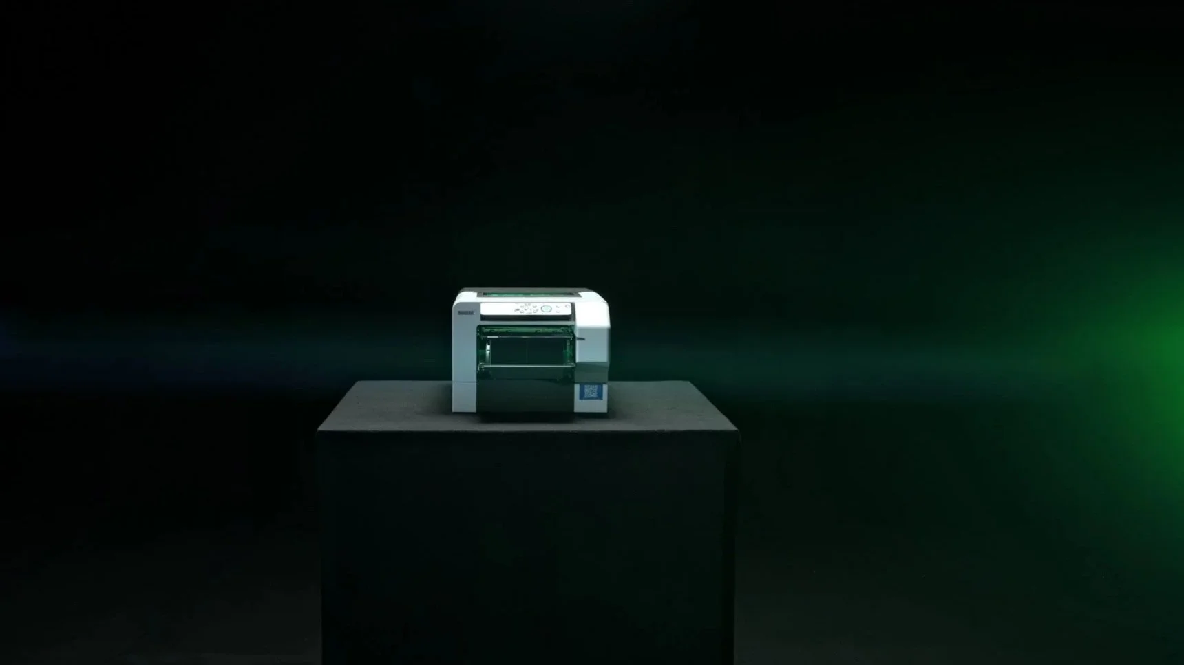 The PrintoLUX signo displayed on a black pedestal against a dark background with a green light streak.
