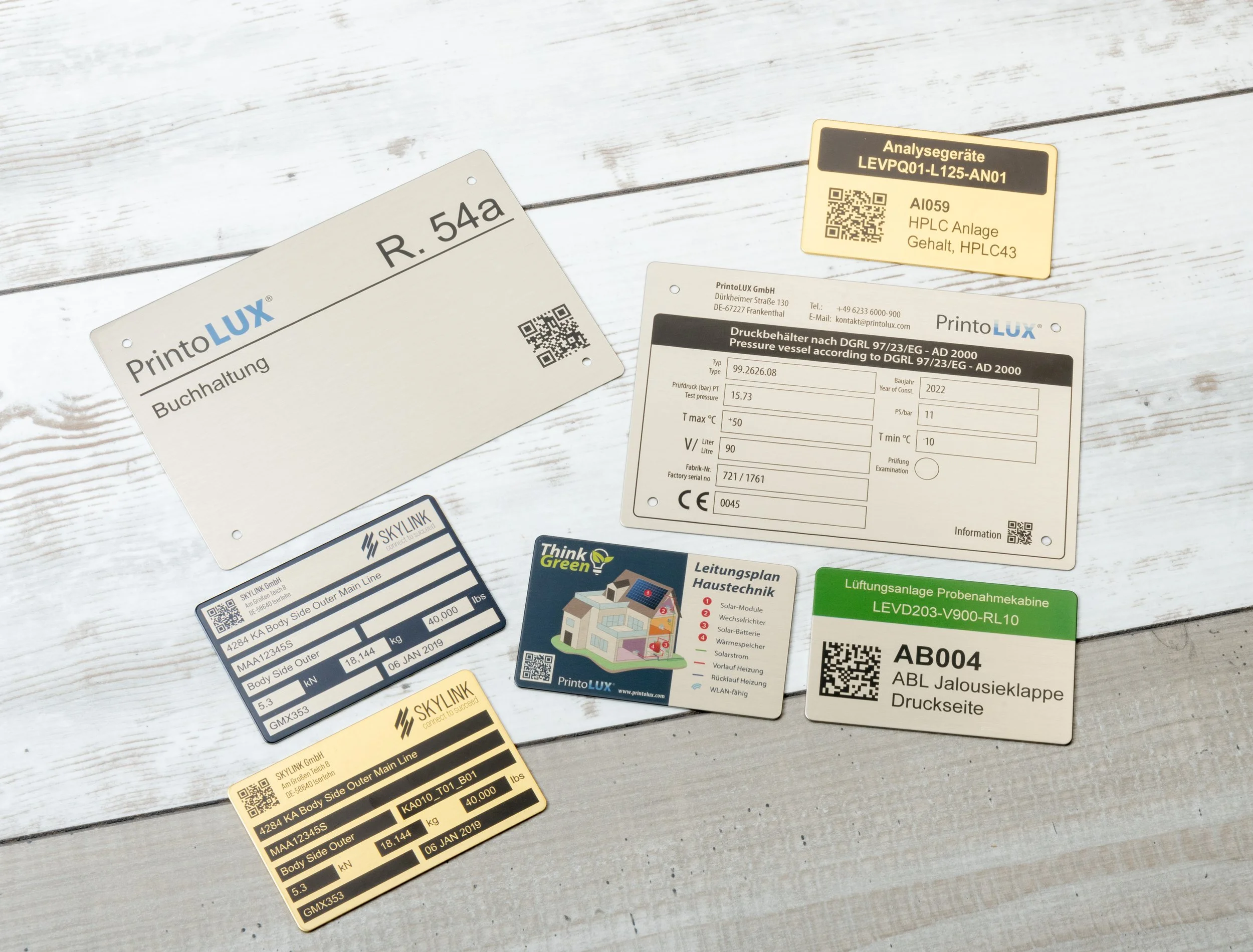 Various labels, tags, and cards related to printolux, placed on a wooden surface.