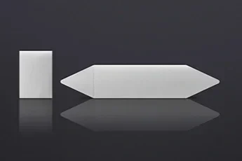 A white rectangular label and a white plastic arrow-shaped label on a reflective black surface.