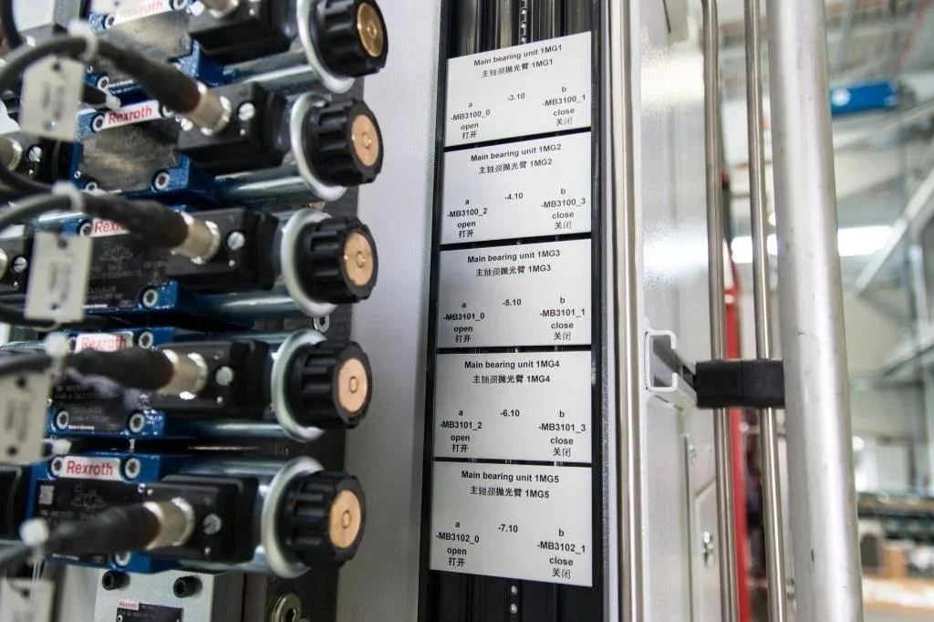 Close-up of industrial machinery with multiple labeled printolux tags and a sheet showing specifications.