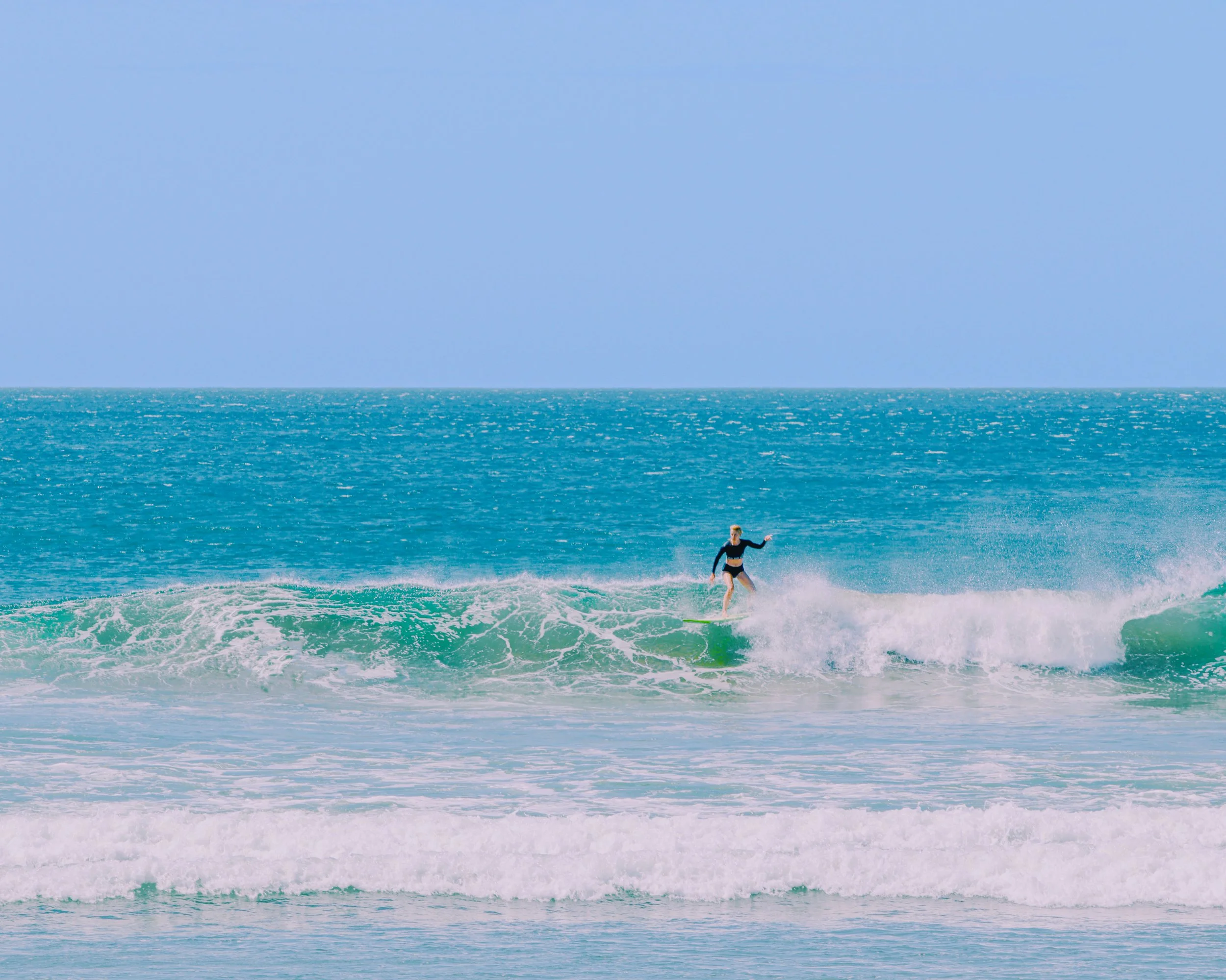 A female surfer riding a wave on a surfboard