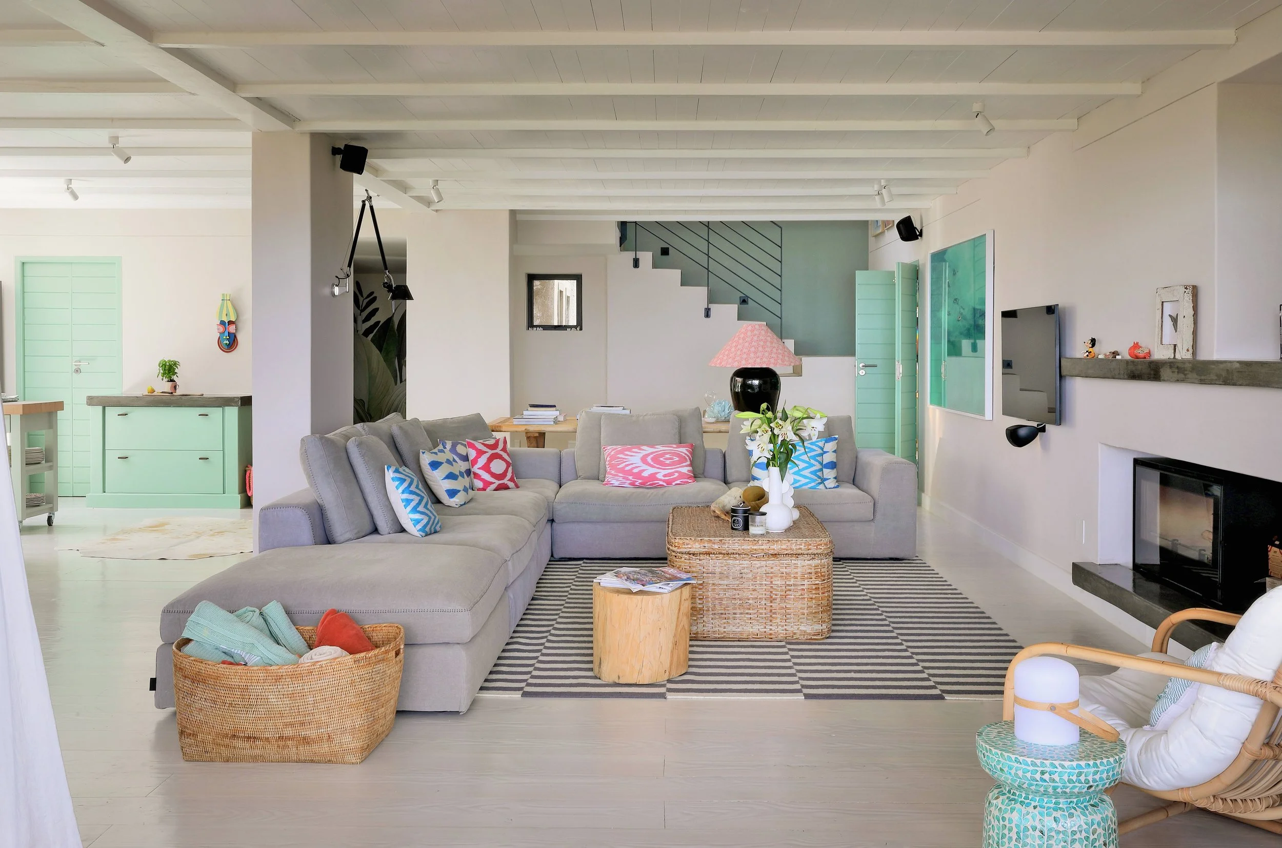 Bright coastal living room with natural cane and seagrass textures, Llandudno Cape Town holiday home interior design by Anja Lehne | Fabliving