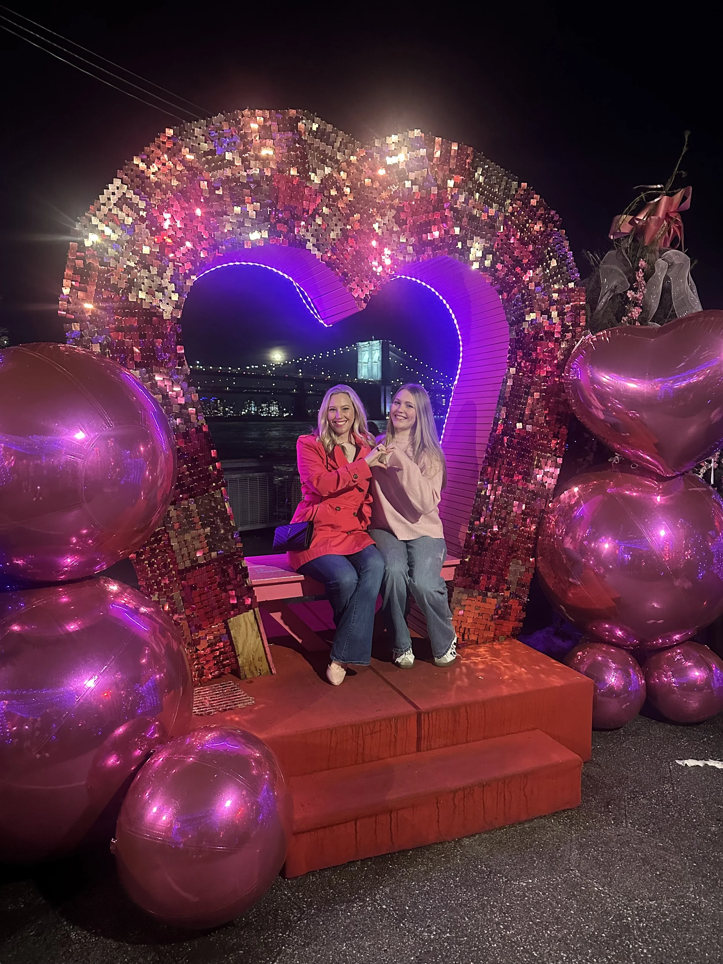 Mary Allison Jensen, LICSW, posing with her daughter in front of a glittery heart installation — the human behind A Legacy of Healing.