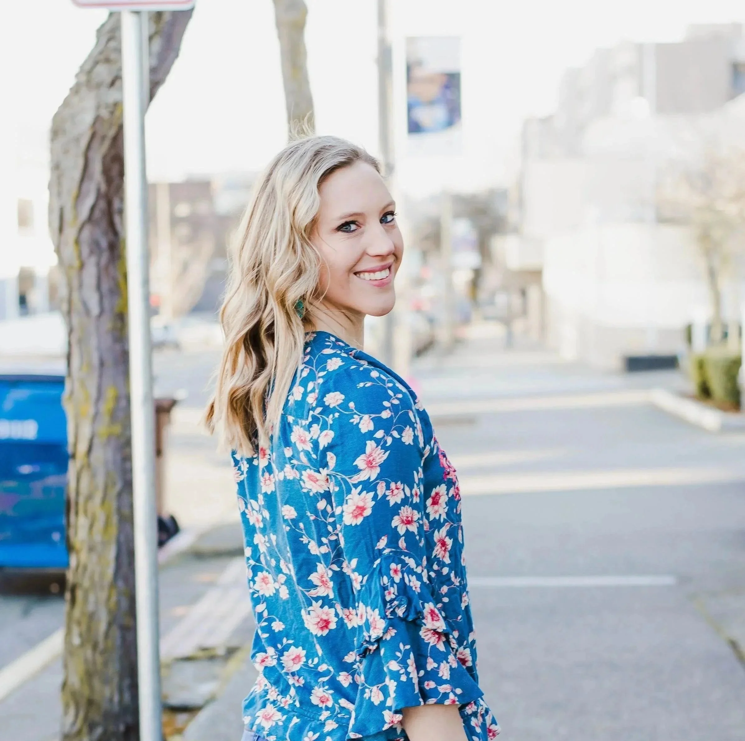 12:26 PMMary Allison Jensen, LICSW, founder of A Legacy of Healing, smiling over her shoulder outdoors in a blue floral top — clinician, women's wellness educator, and conscious self-leadership advocate.