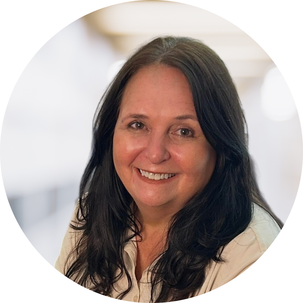 A smiling woman with long dark hair in an indoor setting.