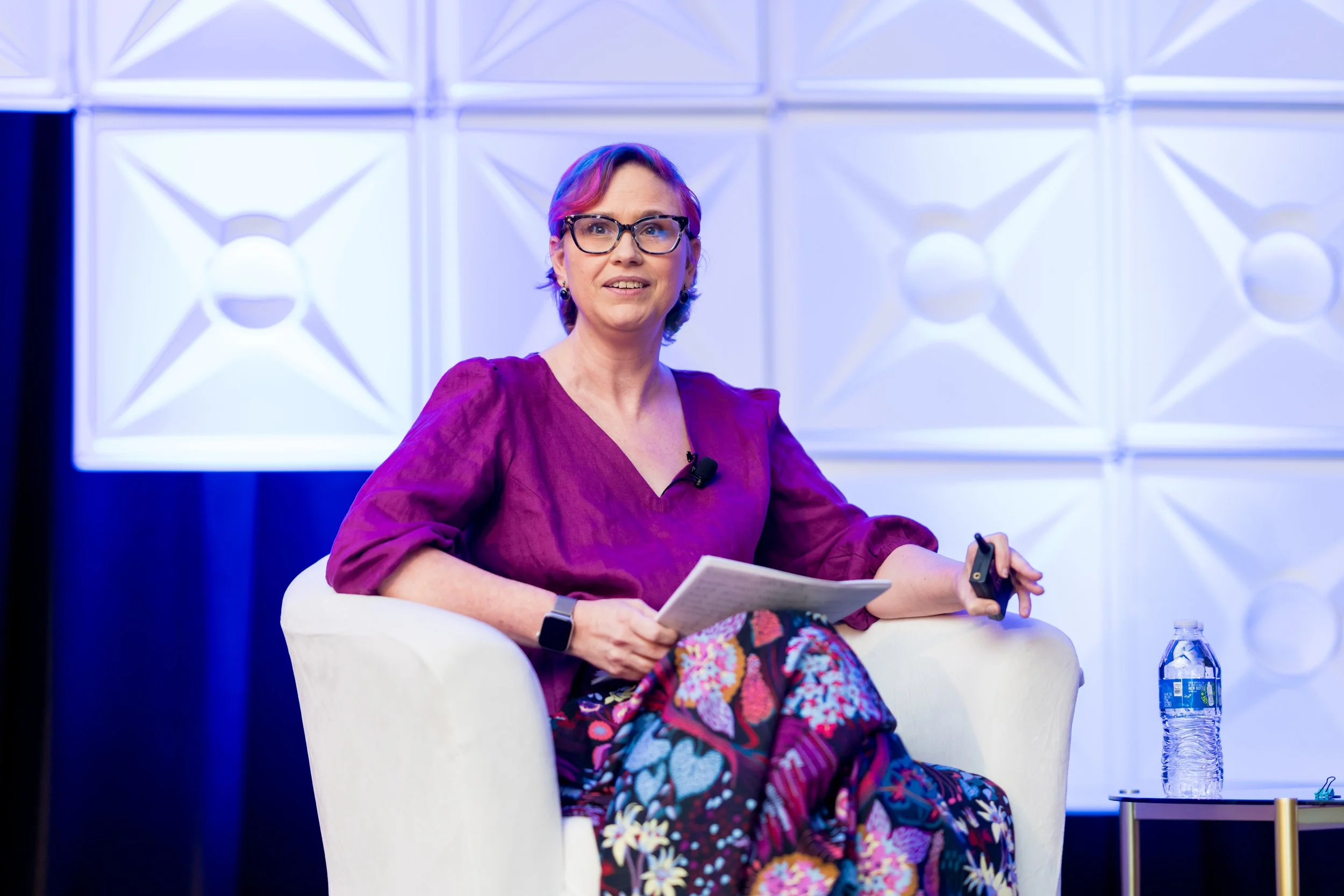 A close up of Rebecca seated on stage delivering a keynote.