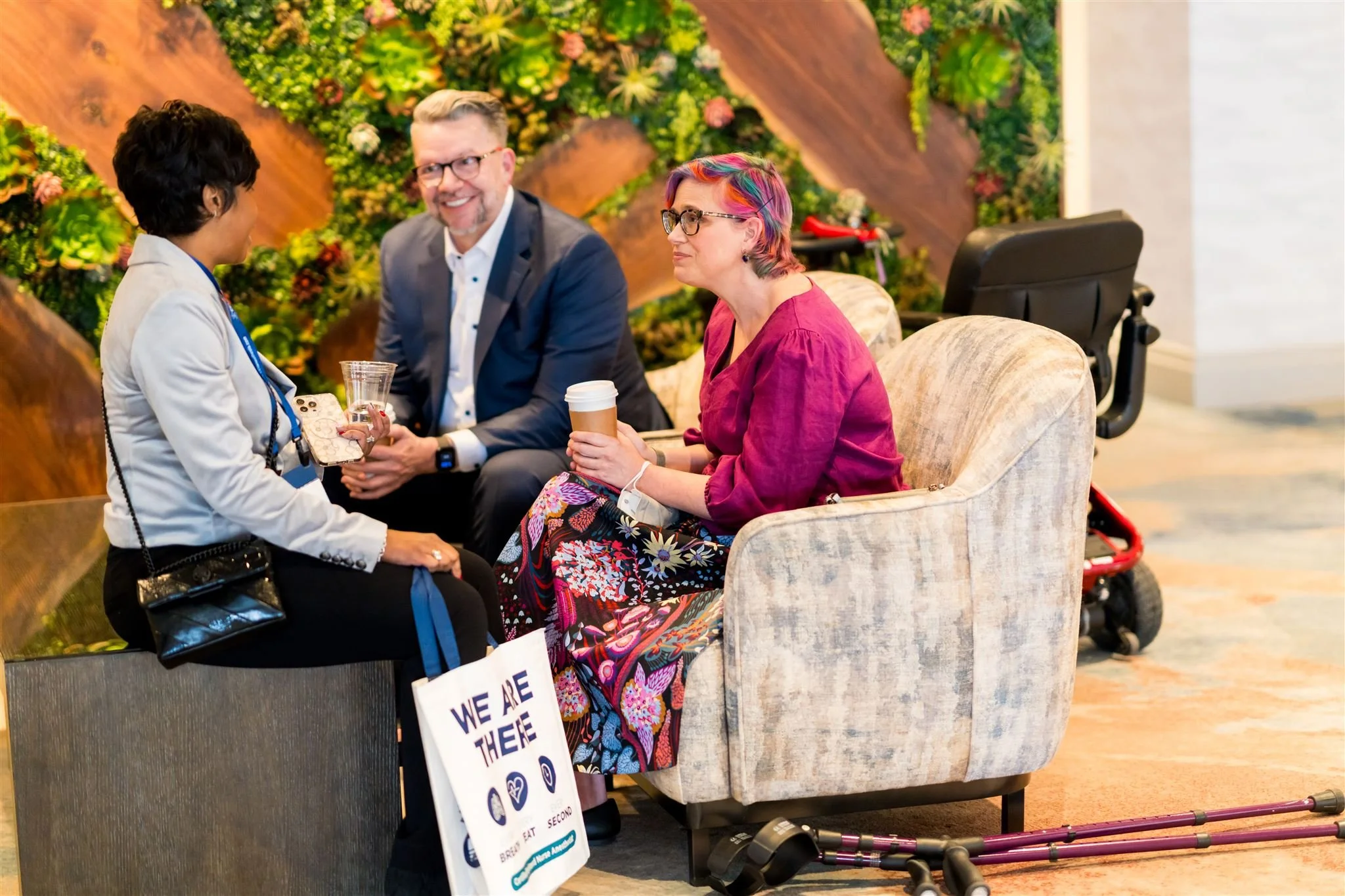 Rebecca sits talking with two conference attendees.