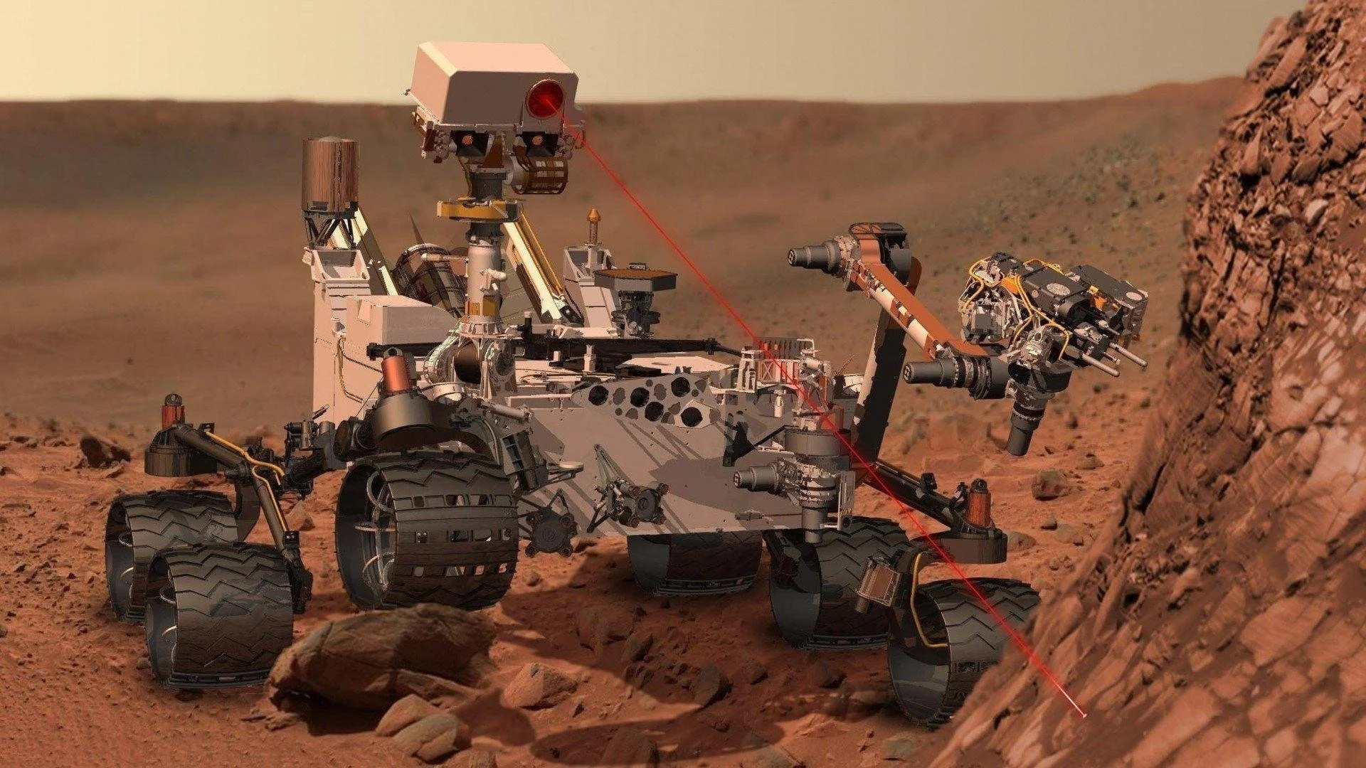 Mars rover on red rocky terrain, with a laser beam emitted from its instrument toward a rock formation.