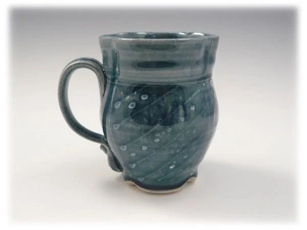 A ceramic mug with a swirling blue and gray glaze pattern.