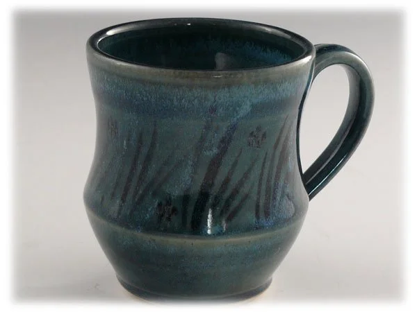 Ceramic mug with a dark interior and a textured blue-green glazed exterior
