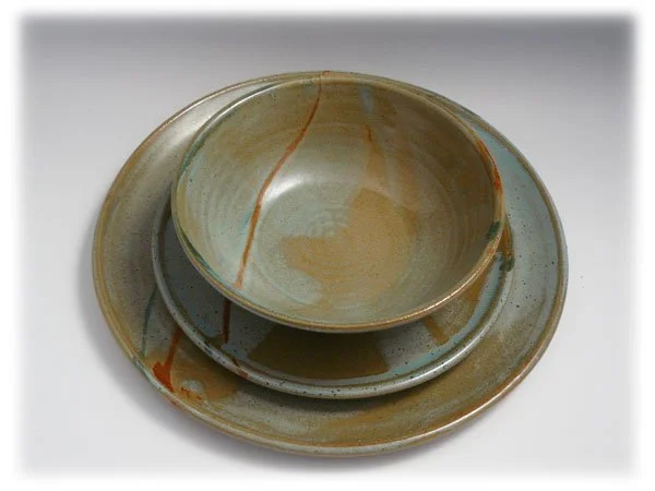 Three stacked ceramic dishes with earth-tone glaze on a white background.