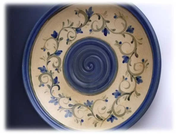 Decorative ceramic plate with blue floral patterns and a spiral design in the center.