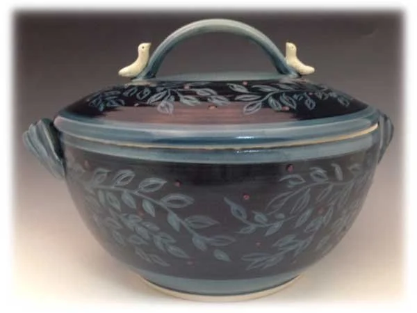 Decorative ceramic soup tureen with lid, featuring a dark blue glaze and leaf pattern, topped with two bird-shaped handles.