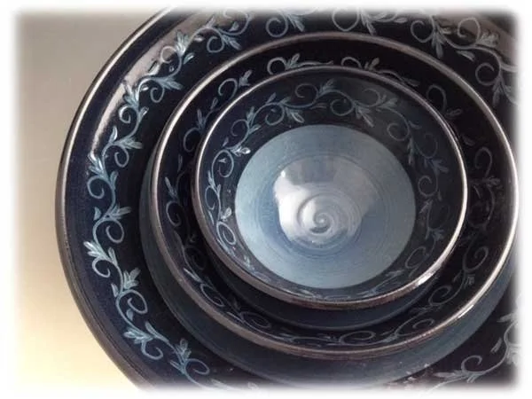 Close-up of a spiral staircase with ornate black and white design, viewed from below.