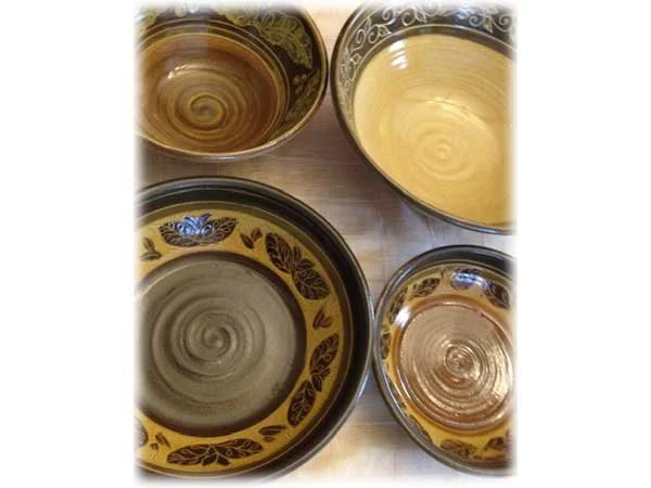 Five decorative bowls with swirling patterns, some filled with liquid.