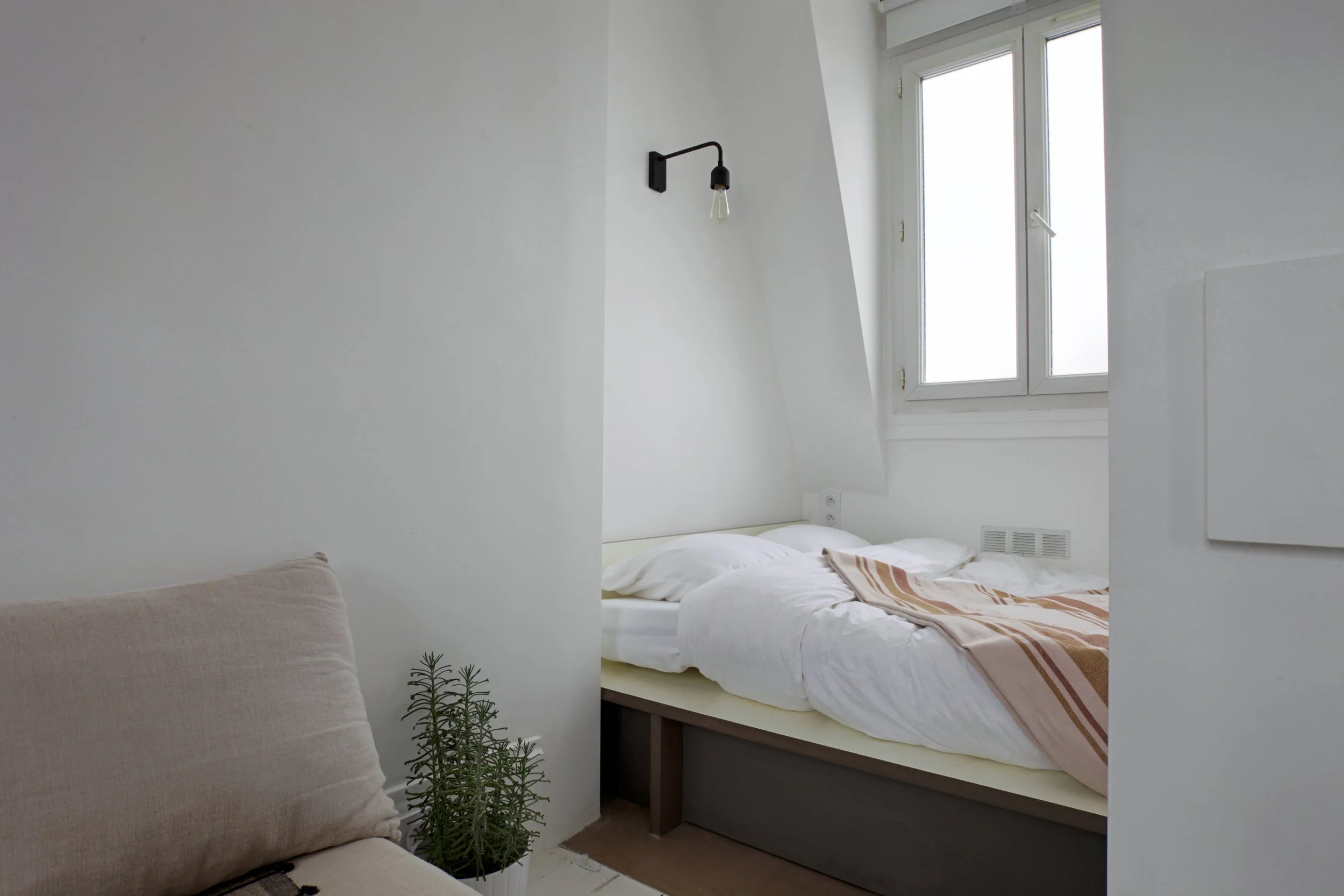 Coin couchage d'un loft au dernier étage d'un immeuble des Bâtignolles