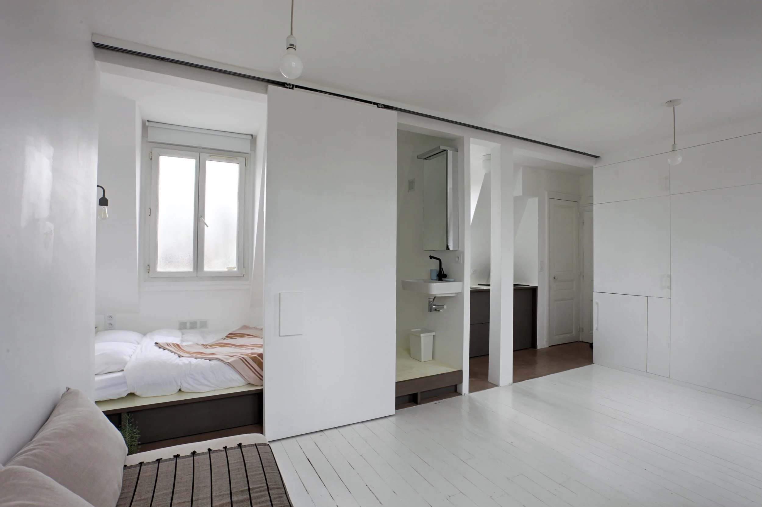 Coin nuit et coin douche ouverts d'un loft au dernier étage d'un immeuble des Bâtignolles