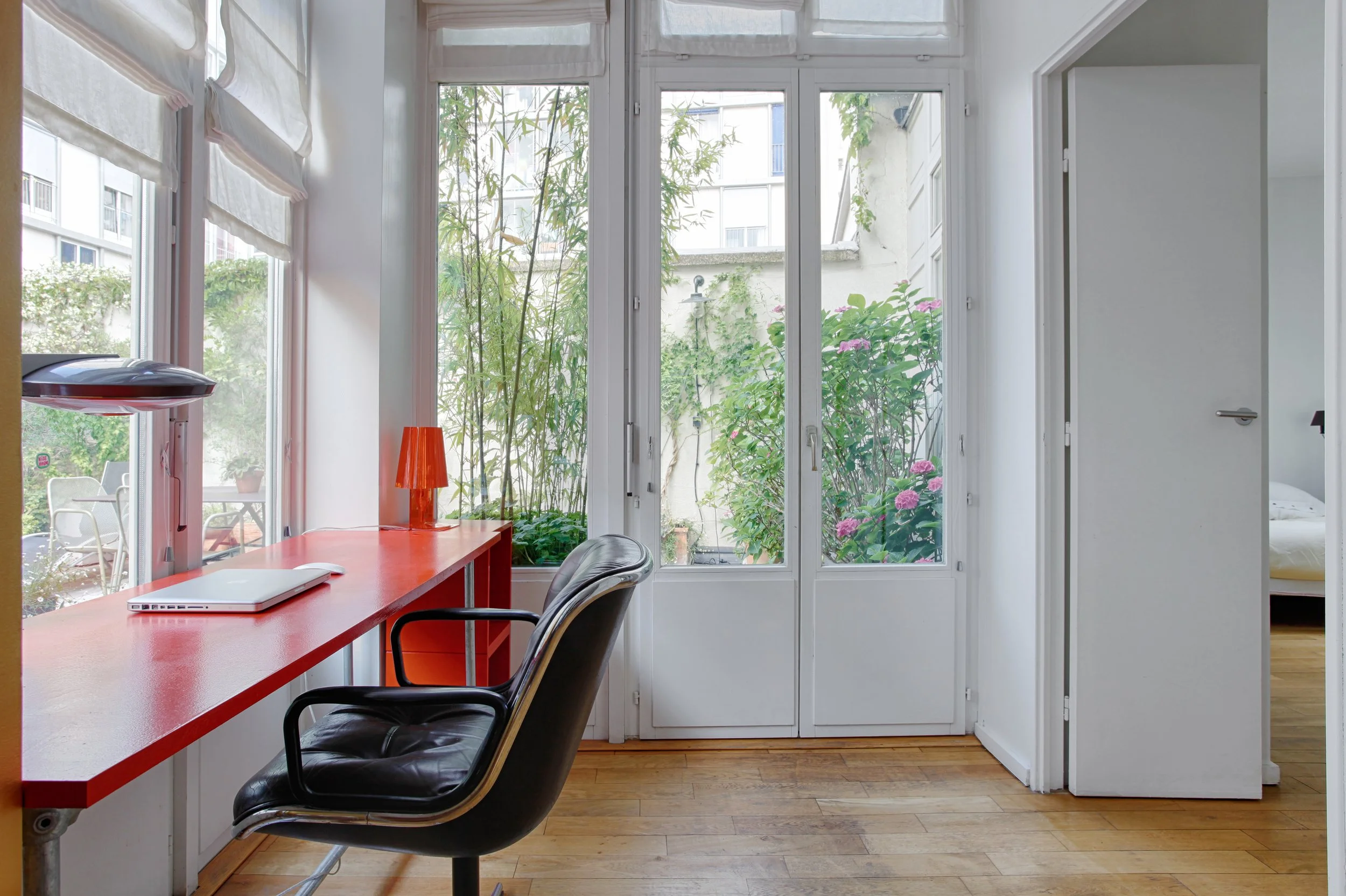 Bureau donnant sur la terrasse fleurie d'un loft en bordure du Marais