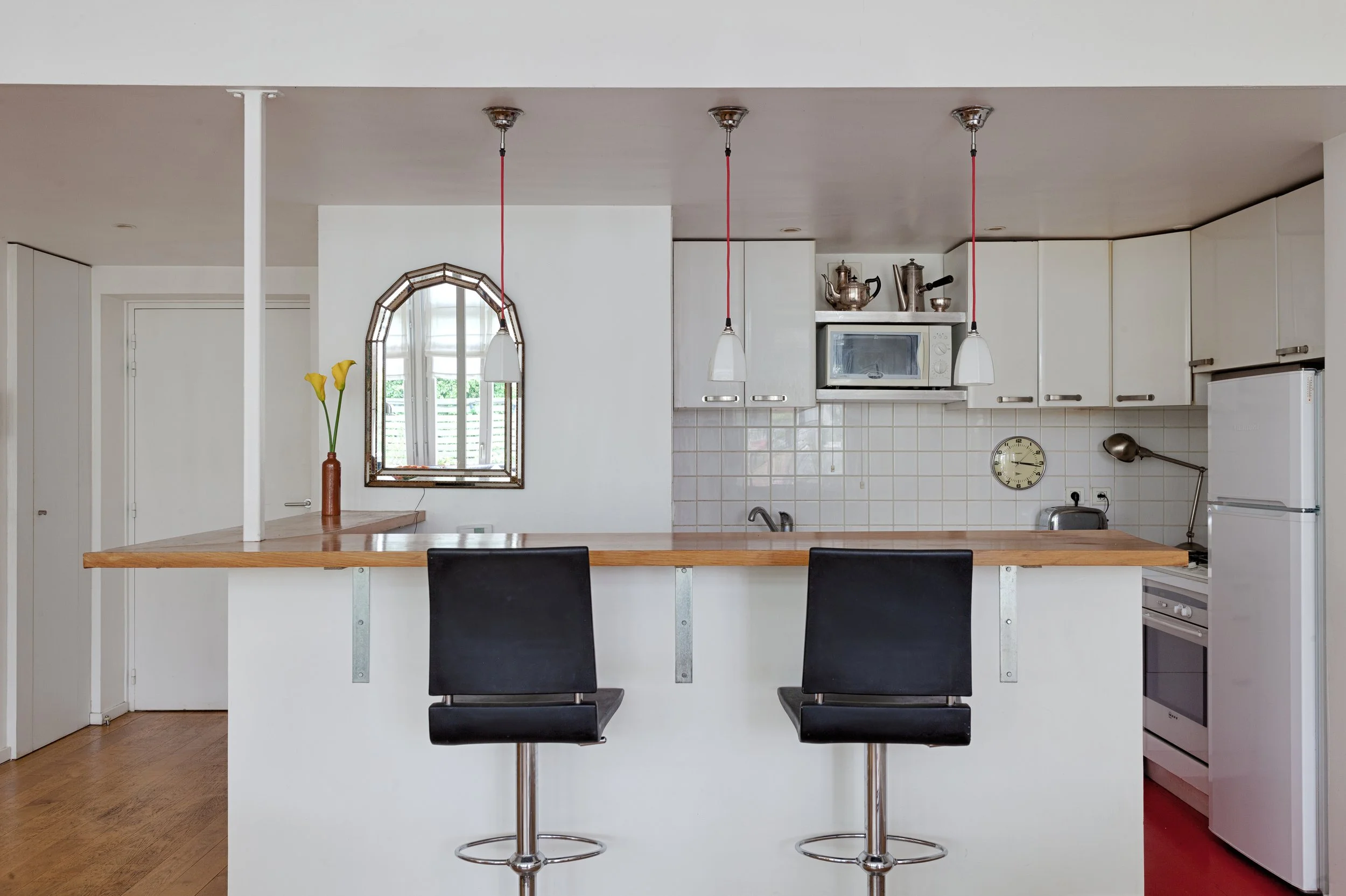 Cuisine ouverte sur le séjour-salle à manger d'un loft avec terrasse en bordure du Marais