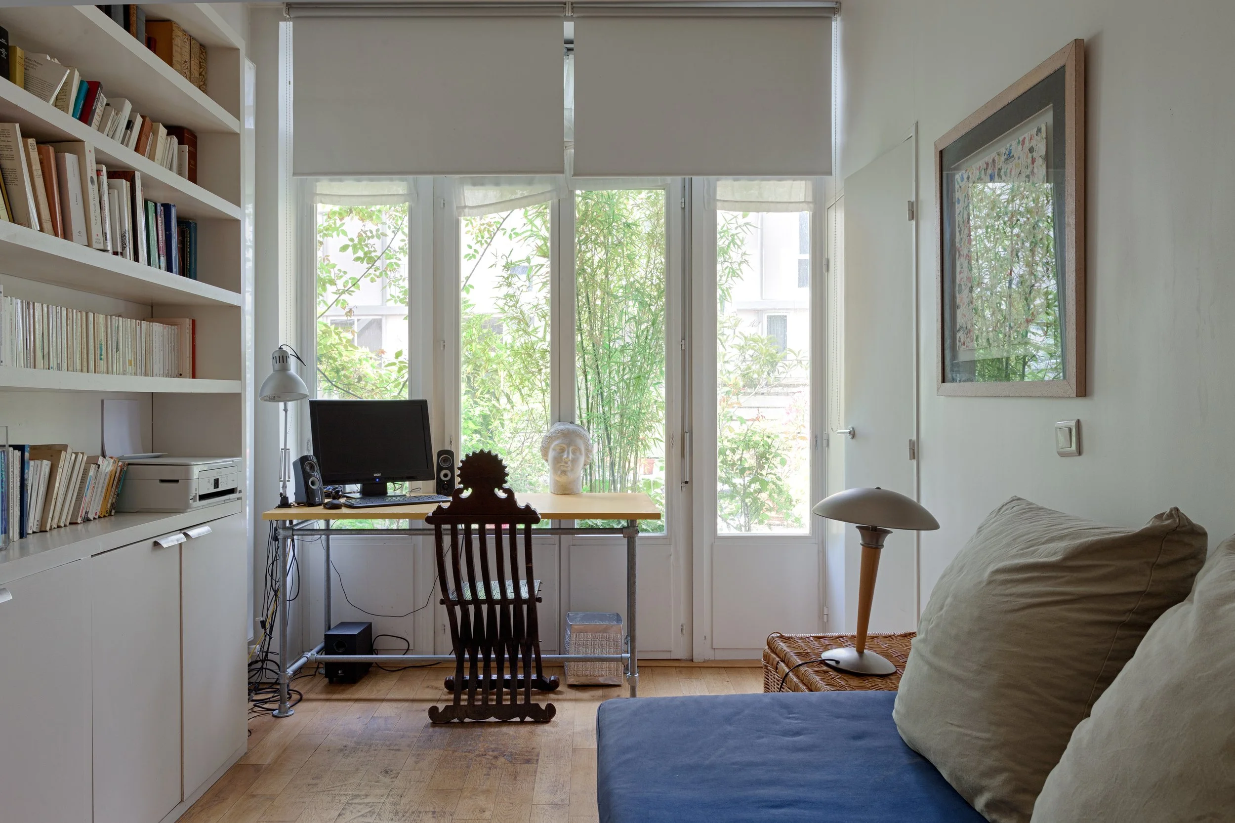 Chambre avec coin bureau et bibliothèque donnant sur la terrasse d'un loft en bordure du Marais