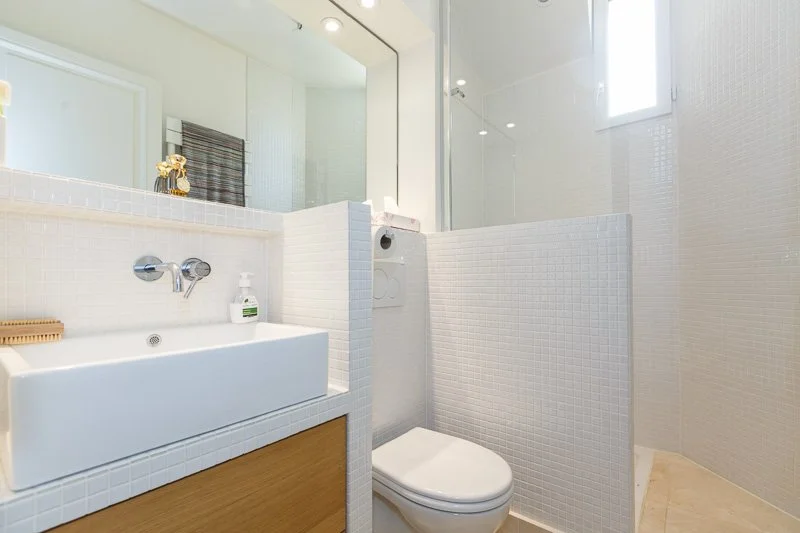 Salle d'eau avec douche à l'italienne et petit carreaux crème dans un appartement à la frontière du Maris