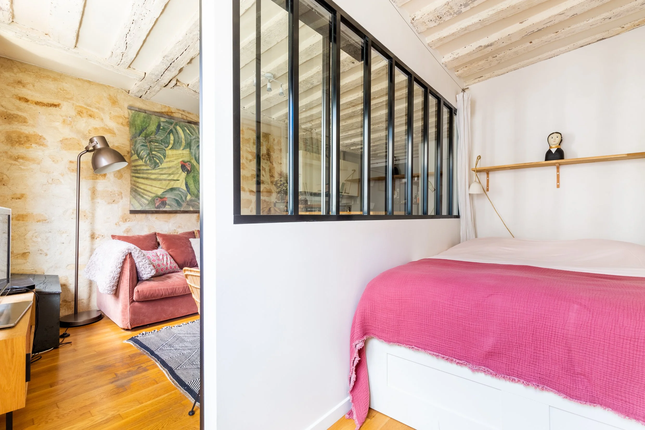 Coin nuit d'un studio avec coin nuit et verrière atelier dans le quartier du Sentier