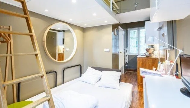 Canapé convertible Muji sous la mezzanine de ce pied-à-terre situé à deux pas de la cathédrale Notre-Dame dans le 5e arrondissement de Paris